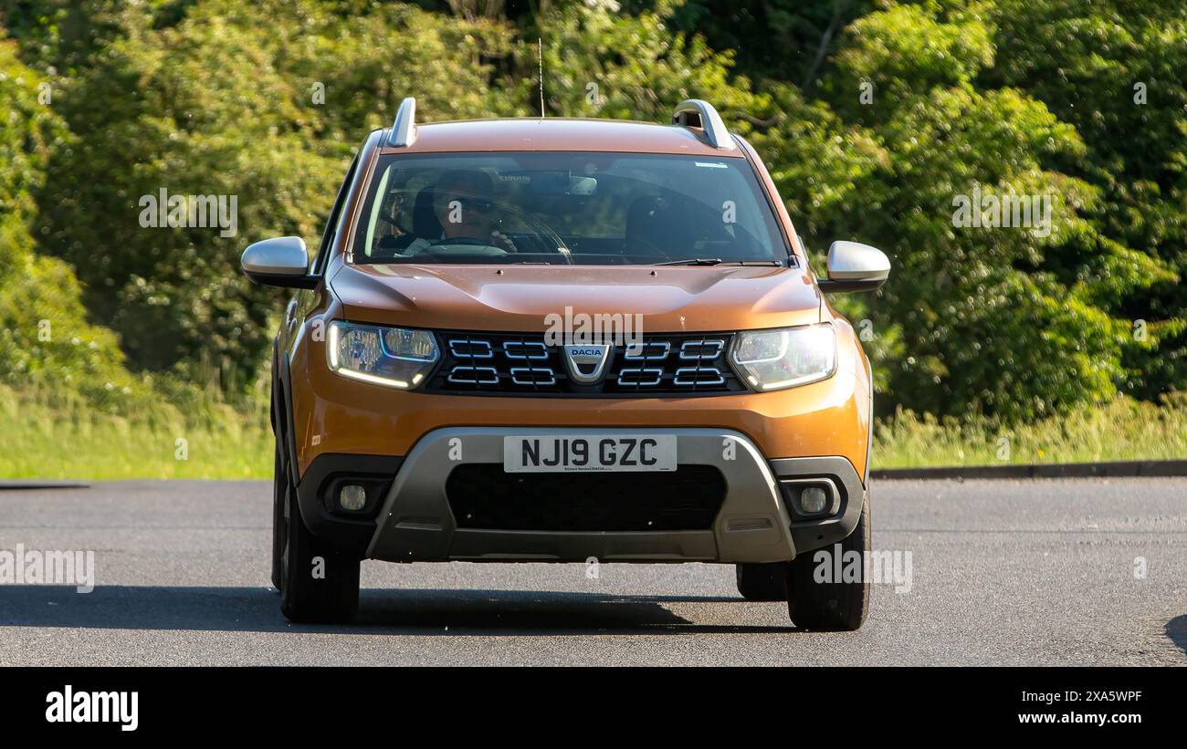 Stony Stratford, Royaume-Uni - 2 juin 2024 : 2019 orange Dacia Duster voiture conduisant sur une route de campagne britannique Banque D'Images