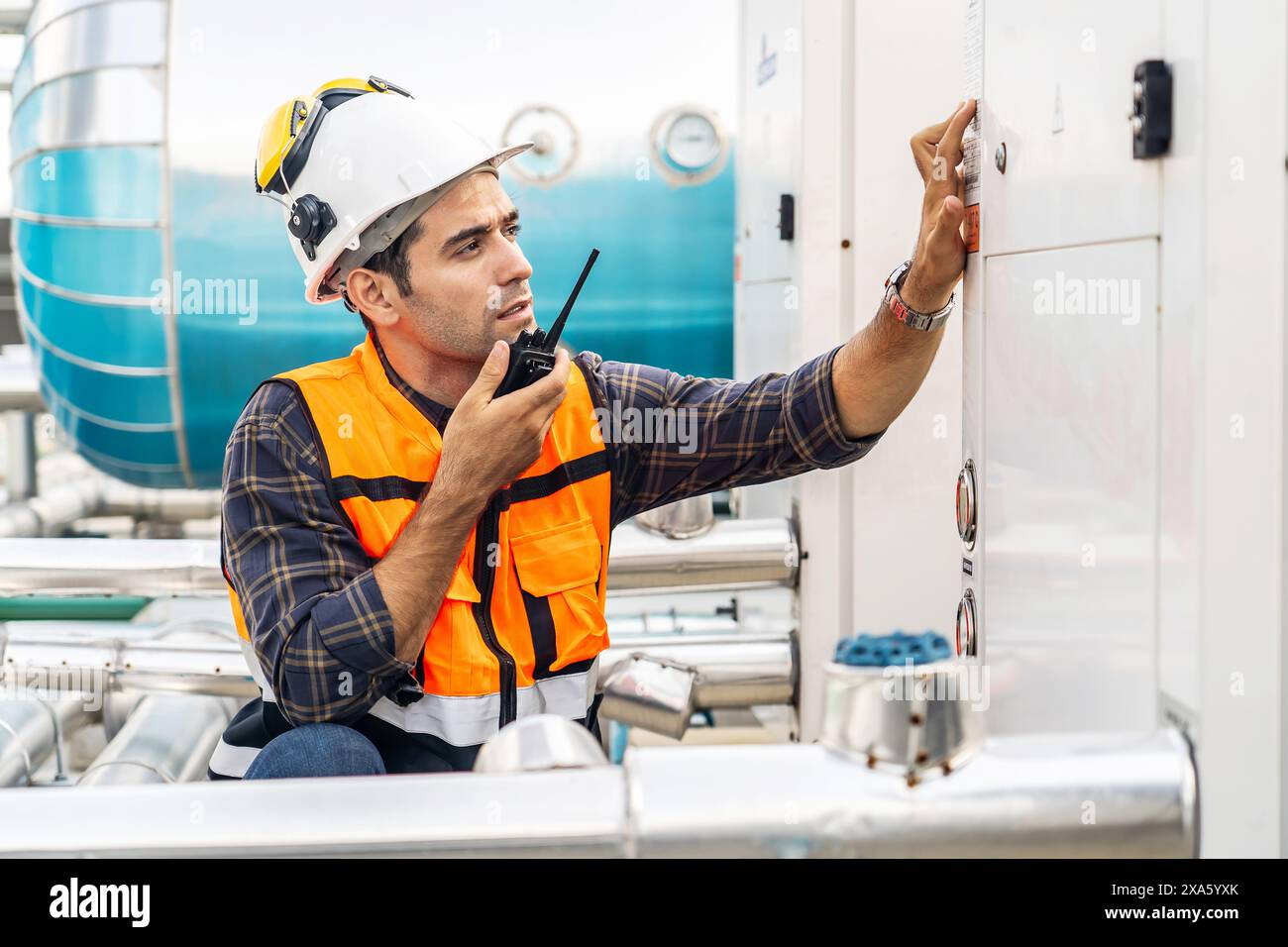 Un contremaître technique discutant à la radio sur la maintenance des systèmes de construction en Thaïlande, Bangkok Banque D'Images