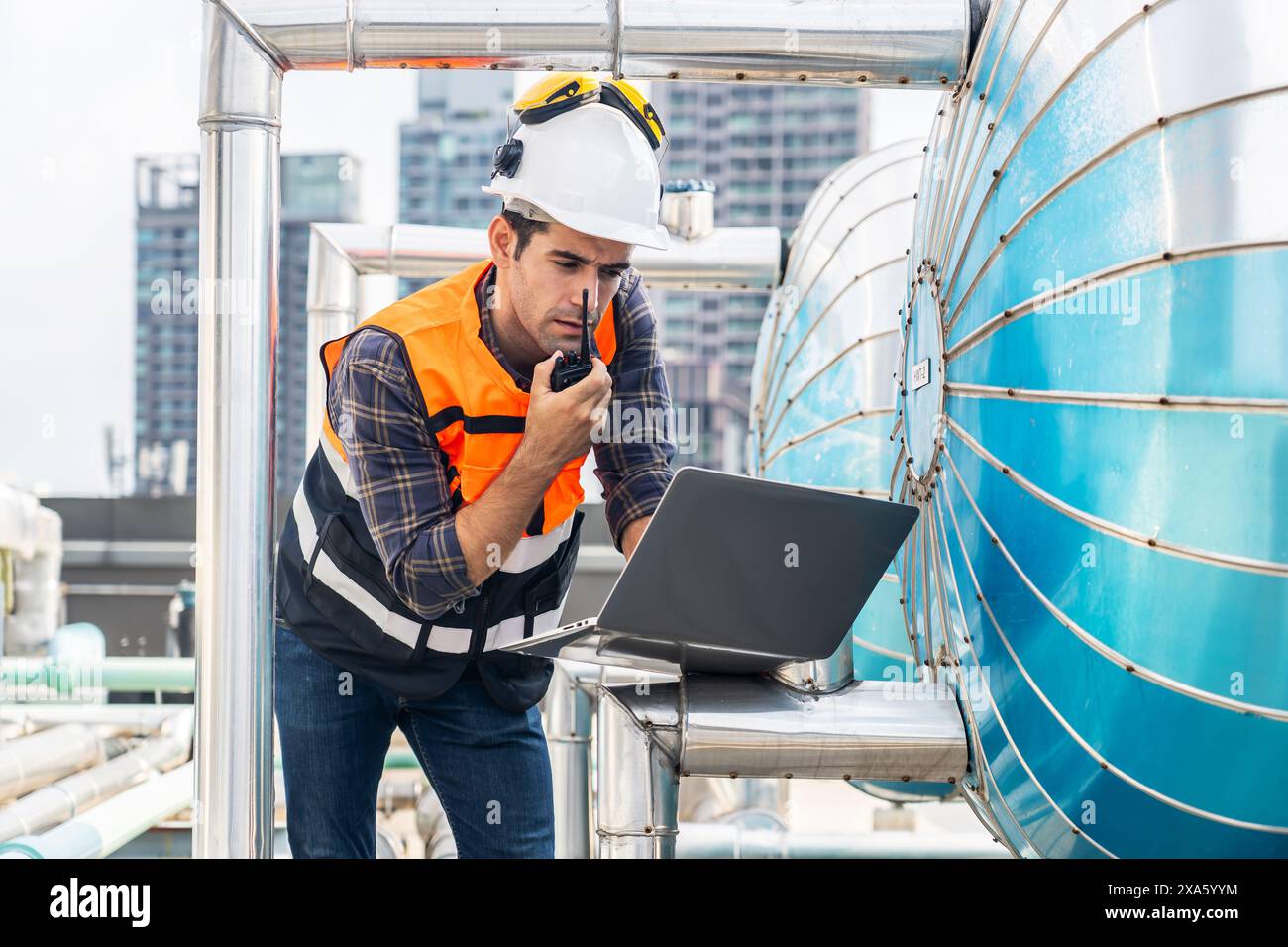 Un contremaître technique discutant à la radio sur la maintenance des systèmes de construction en Thaïlande, Bangkok Banque D'Images