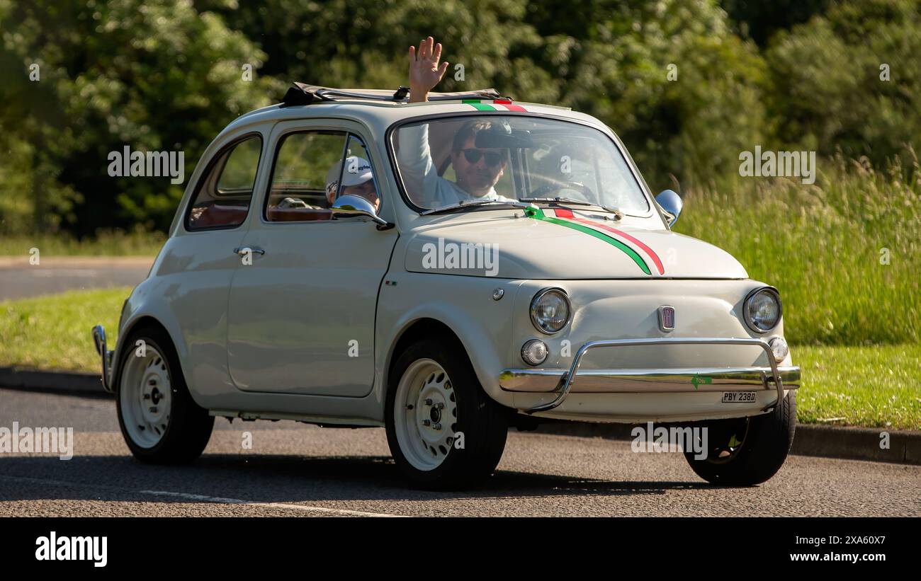 Stony Stratford, Royaume-Uni - 2 juin 2024 : 1966 blanc Fiat 500 Classic petite voiture conduisant sur une route de campagne britannique Banque D'Images