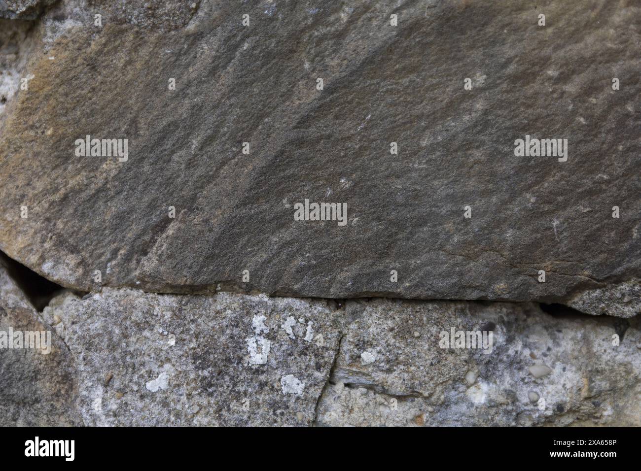 photo en gros plan d'une surface murale texturée en pierre gris foncé présentant des fissures et des éclats Banque D'Images