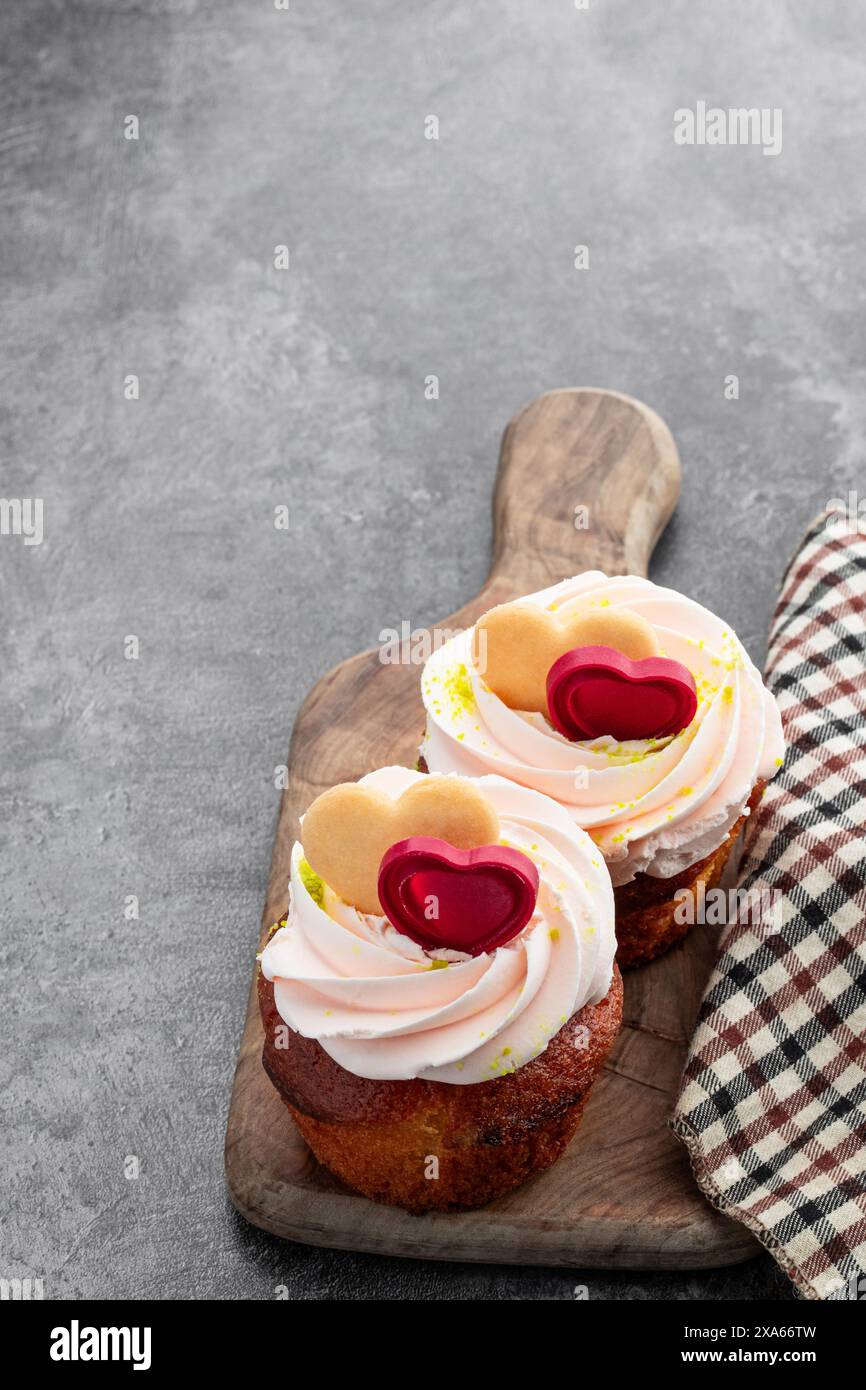 Cupcakes décorés de cœurs de sucre sur table grise Banque D'Images