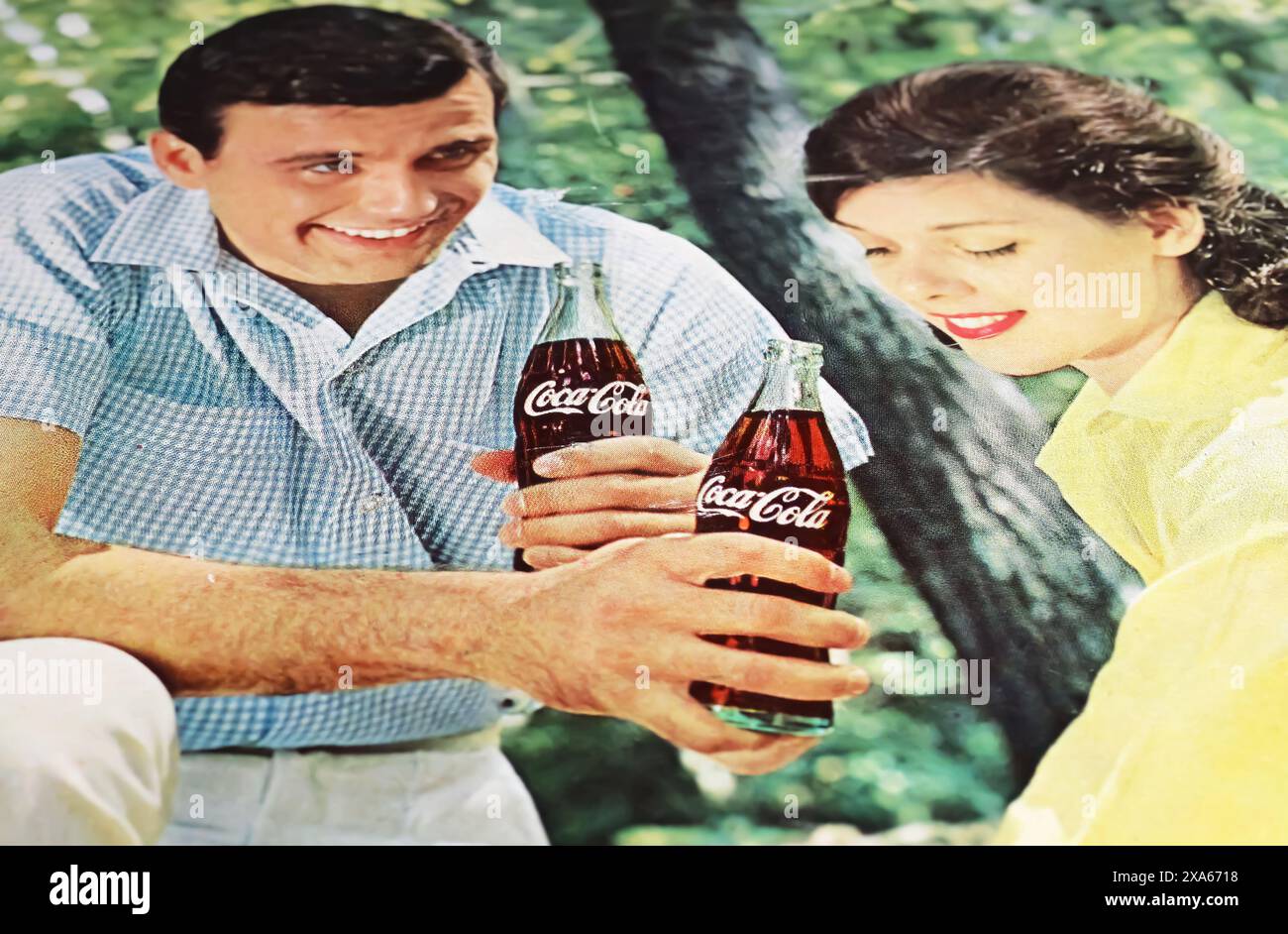 Viersen, Allemagne - 9 mai. 2024 : vieux magazine rétro américain Coca Cola publicité avec un jeune couple flirteur dans le parc à partir de 1965 Banque D'Images