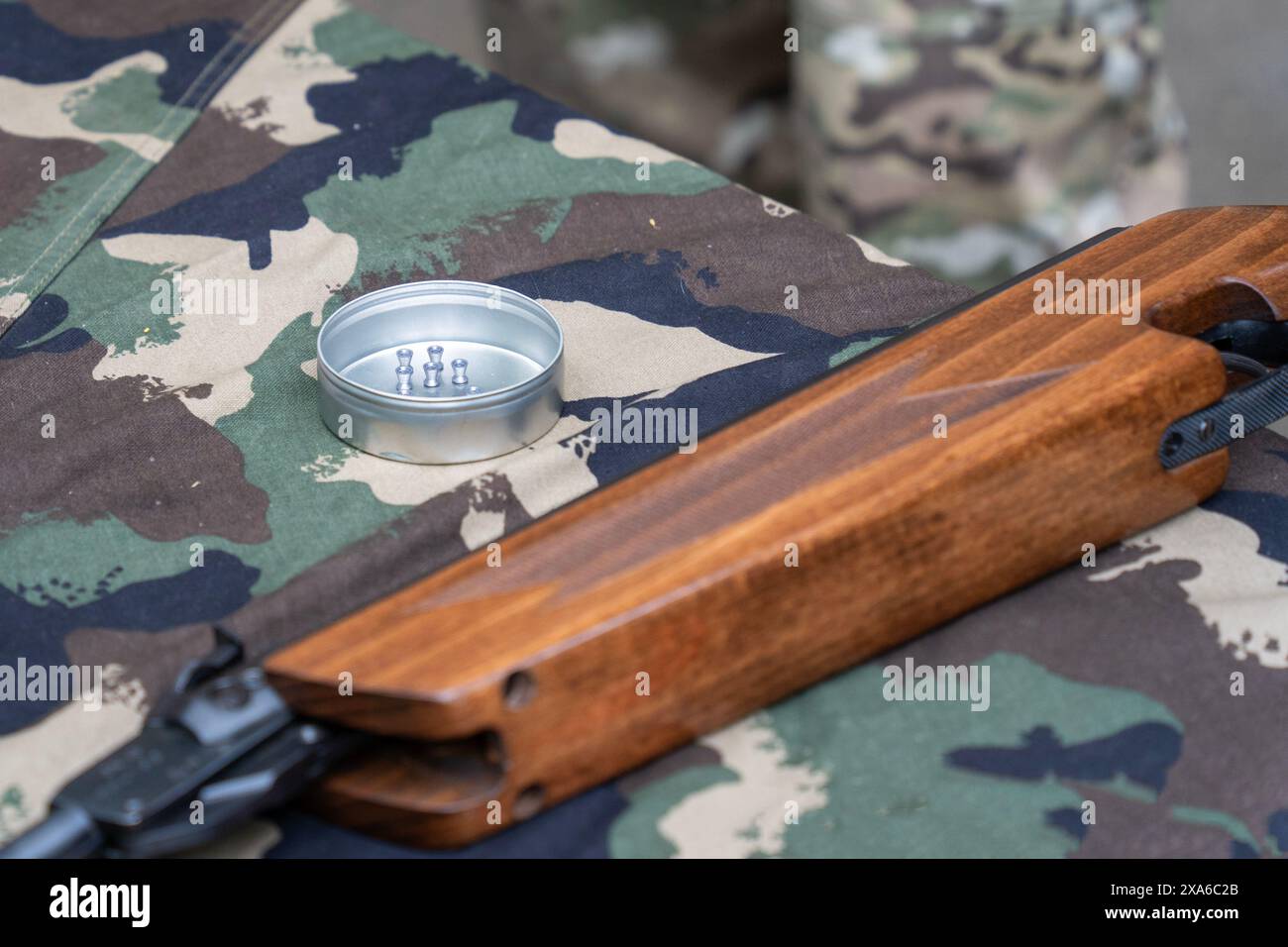 Carabine à air comprimé et munition de carabine à air comprimé sur une table de camouflage Banque D'Images