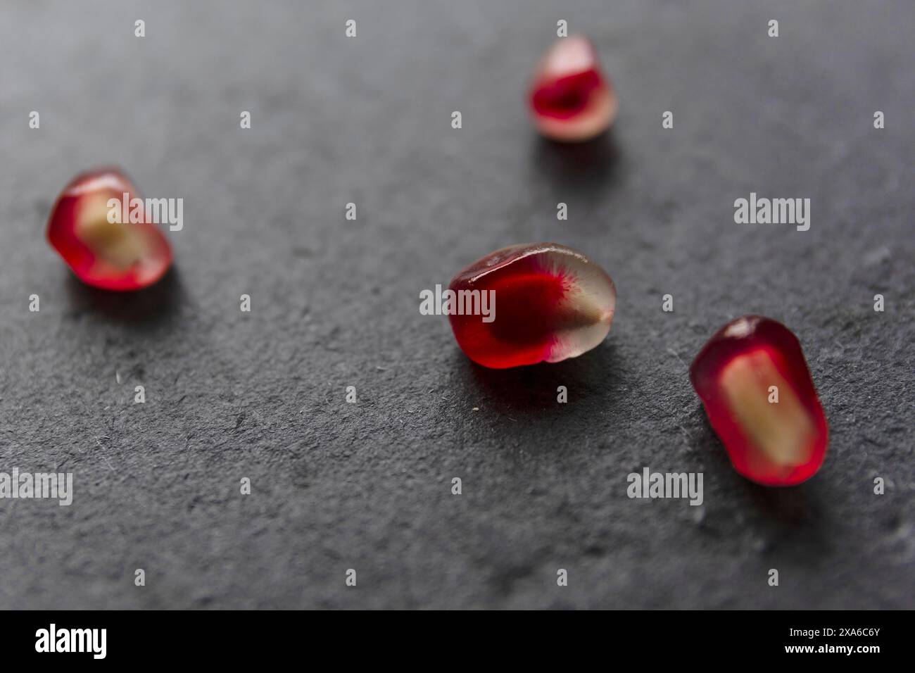 gros plan macro de graines de grenade sur fond noir foncé, macro photographie de natures mortes alimentaires discrètes Banque D'Images