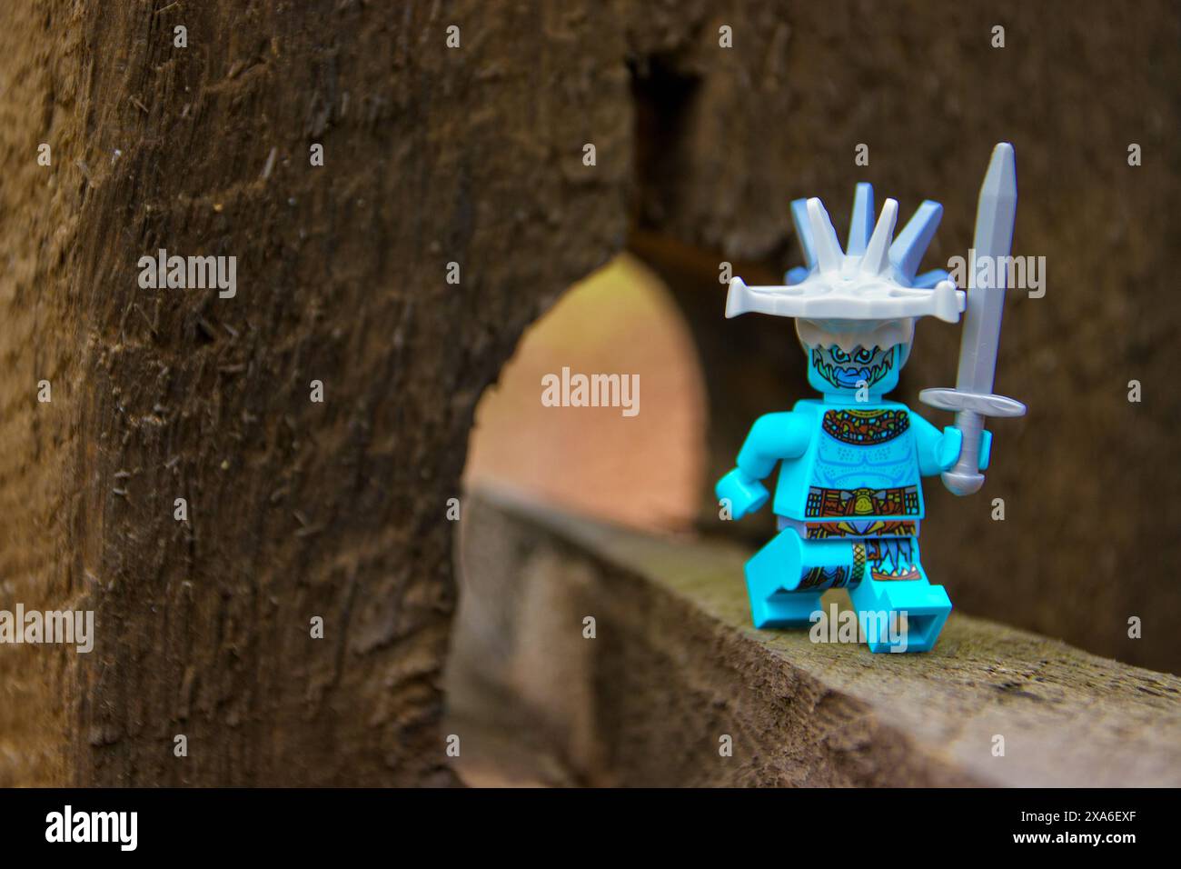 Jouet, mini bleu, personnage comique. Super méchant du film de super-héros, tenant une épée. Fond extérieur. Banque D'Images