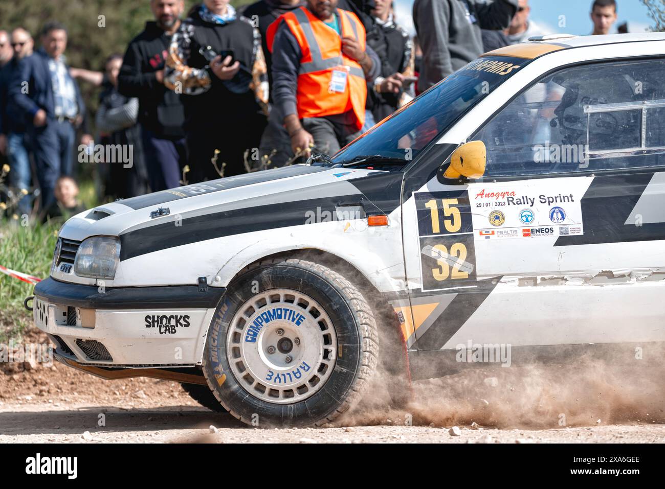 Anogyra, Chypre - 29 janvier 2023 : action shot d'une voiture de rallye Volkswagen Golf III tournant brusquement sur une piste de terre avec des spectateurs en arrière-plan Banque D'Images