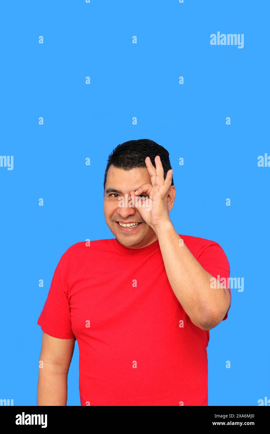 L'homme adulte latin à la peau foncée fait le signe OK avec ses doigts montrant positif et heureux Banque D'Images L'homme adulte latin à la peau foncée fait le signe OK avec ses doigts montrant positif et heureux Banque D'Images