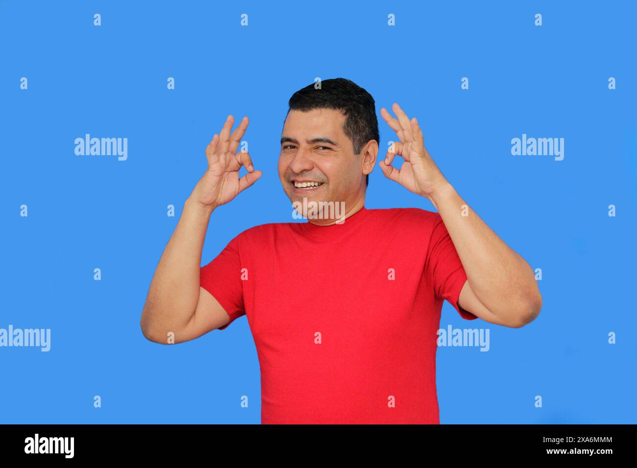 L'homme adulte latin à la peau foncée fait le signe OK avec ses doigts montrant positif et heureux Banque D'Images L'homme adulte latin à la peau foncée fait le signe OK avec ses doigts montrant positif et heureux Banque D'Images