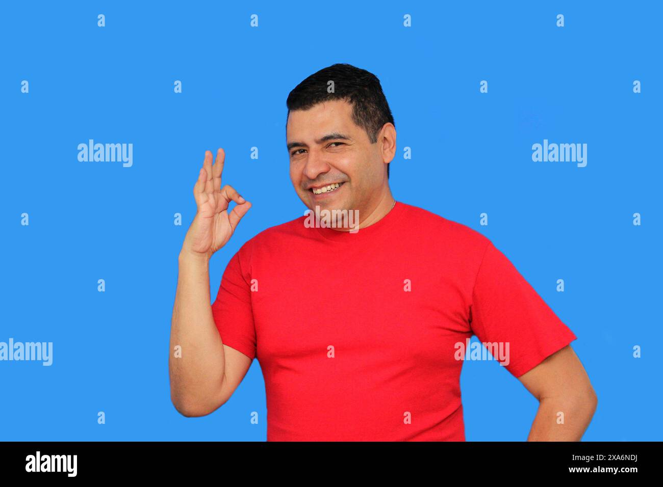 L'homme adulte latin à la peau foncée fait le signe OK avec ses doigts montrant positif et heureux Banque D'Images L'homme adulte latin à la peau foncée fait le signe OK avec ses doigts montrant positif et heureux Banque D'Images