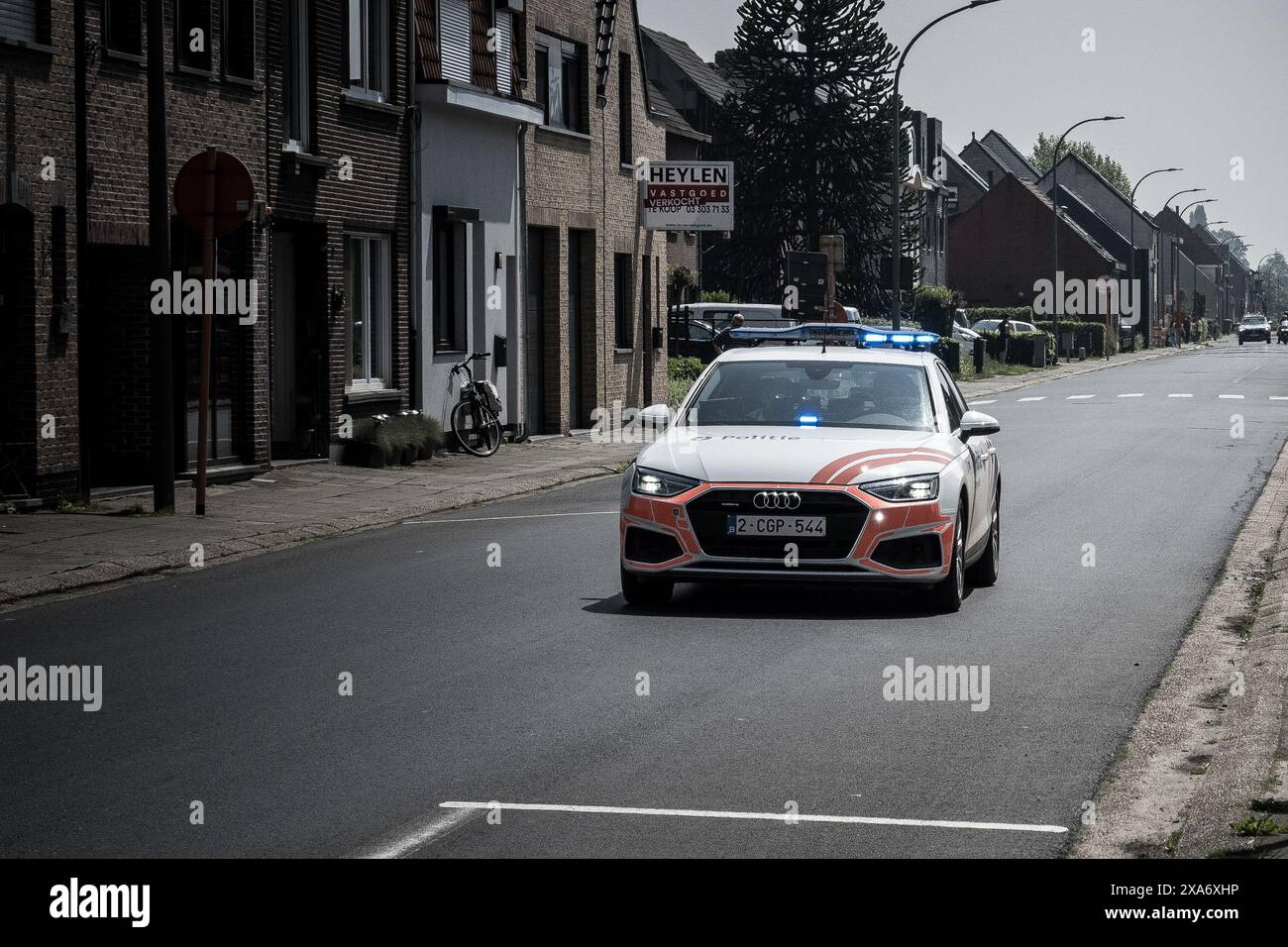 Une voiture de la police fédérale belge conduisant à l'avant avec des feux bleus allumés pendant une course cycliste Banque D'Images