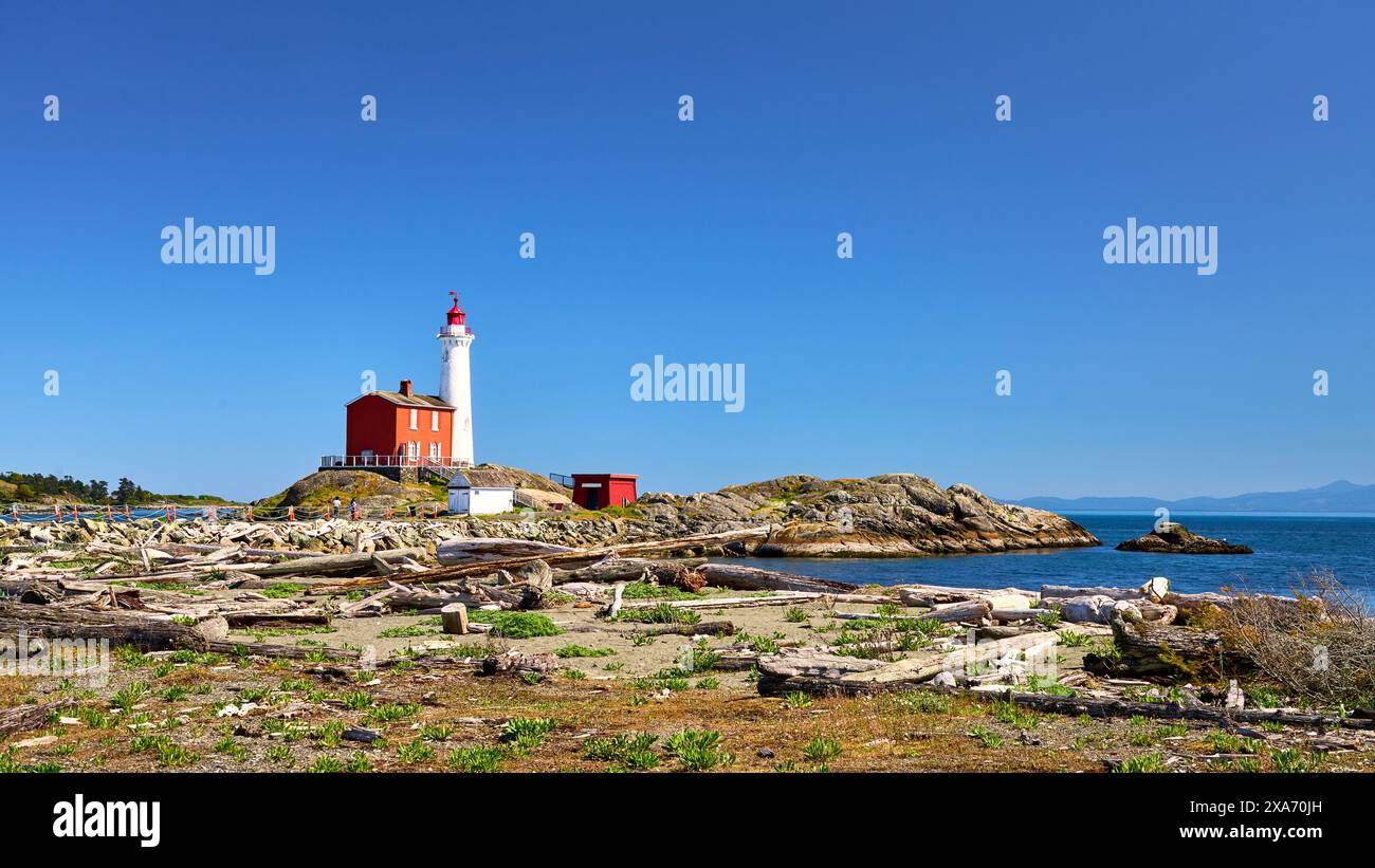 Le majestueux phare Fisgard construit sur la plage rocheuse de l'océan. Banque D'Images