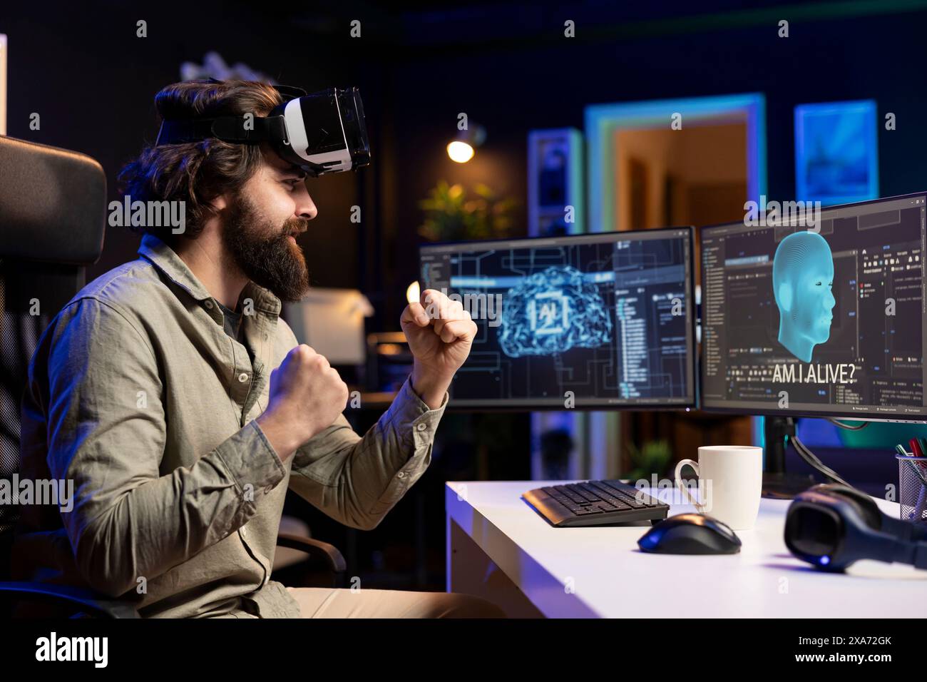 Ingénieur informatique utilisant un casque VR, célébrant après avoir éveillé l'IA sensible posant des questions existentielles. Programmeur joyeux utilisant la technologie de réalité virtuelle pour interagir avec l'intelligence artificielle Banque D'Images