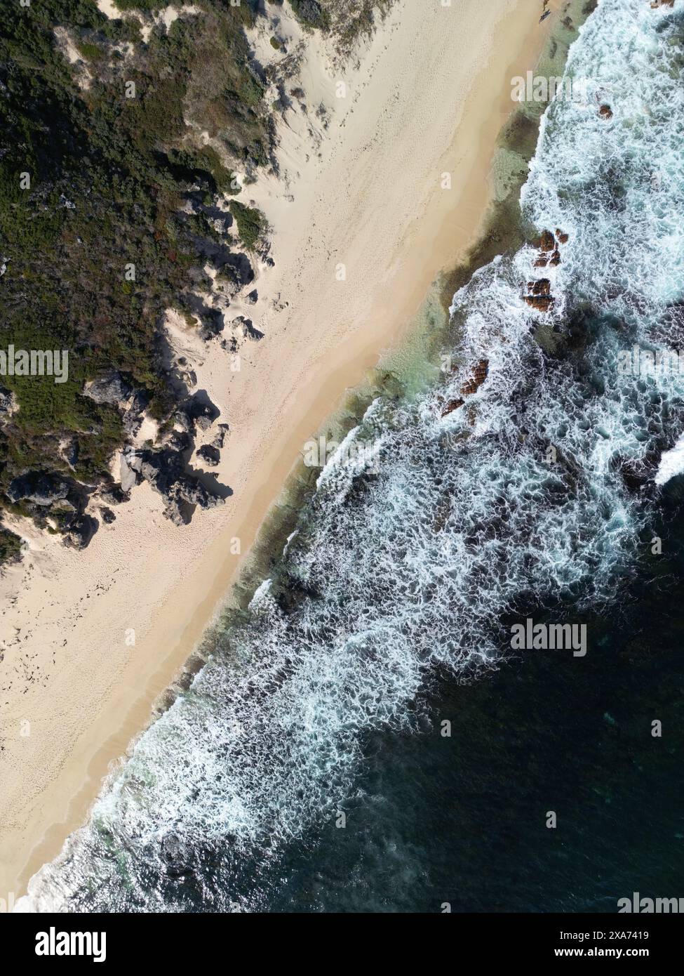 Une vue aérienne des vagues qui s'écrasent sur une plage de sable Banque D'Images