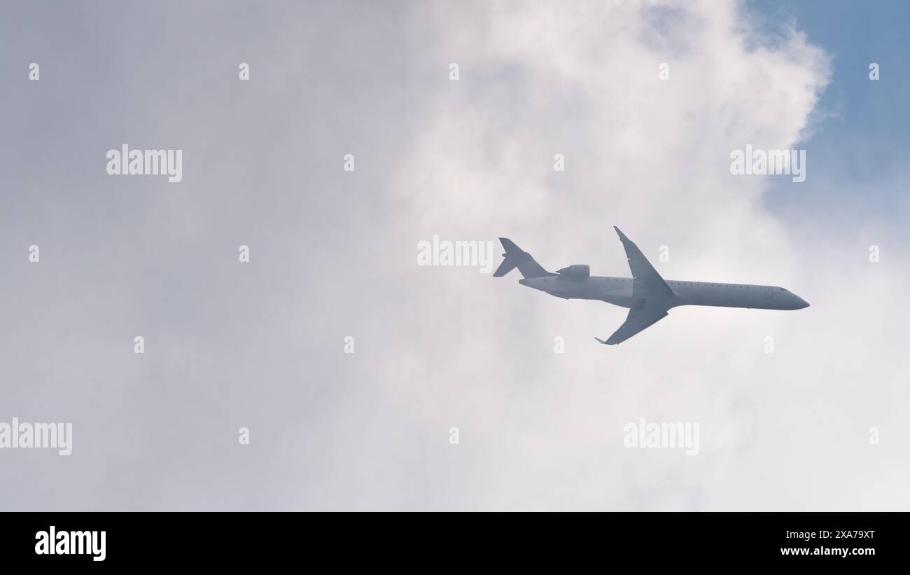 Vue en angle bas de l'avion volant hors des nuages blancs Banque D'Images