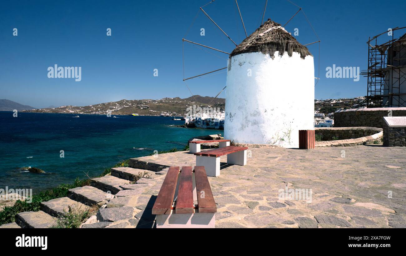 petit moulin à vent se dresse sur la rive à côté d'une vaste étendue d'eau Banque D'Images