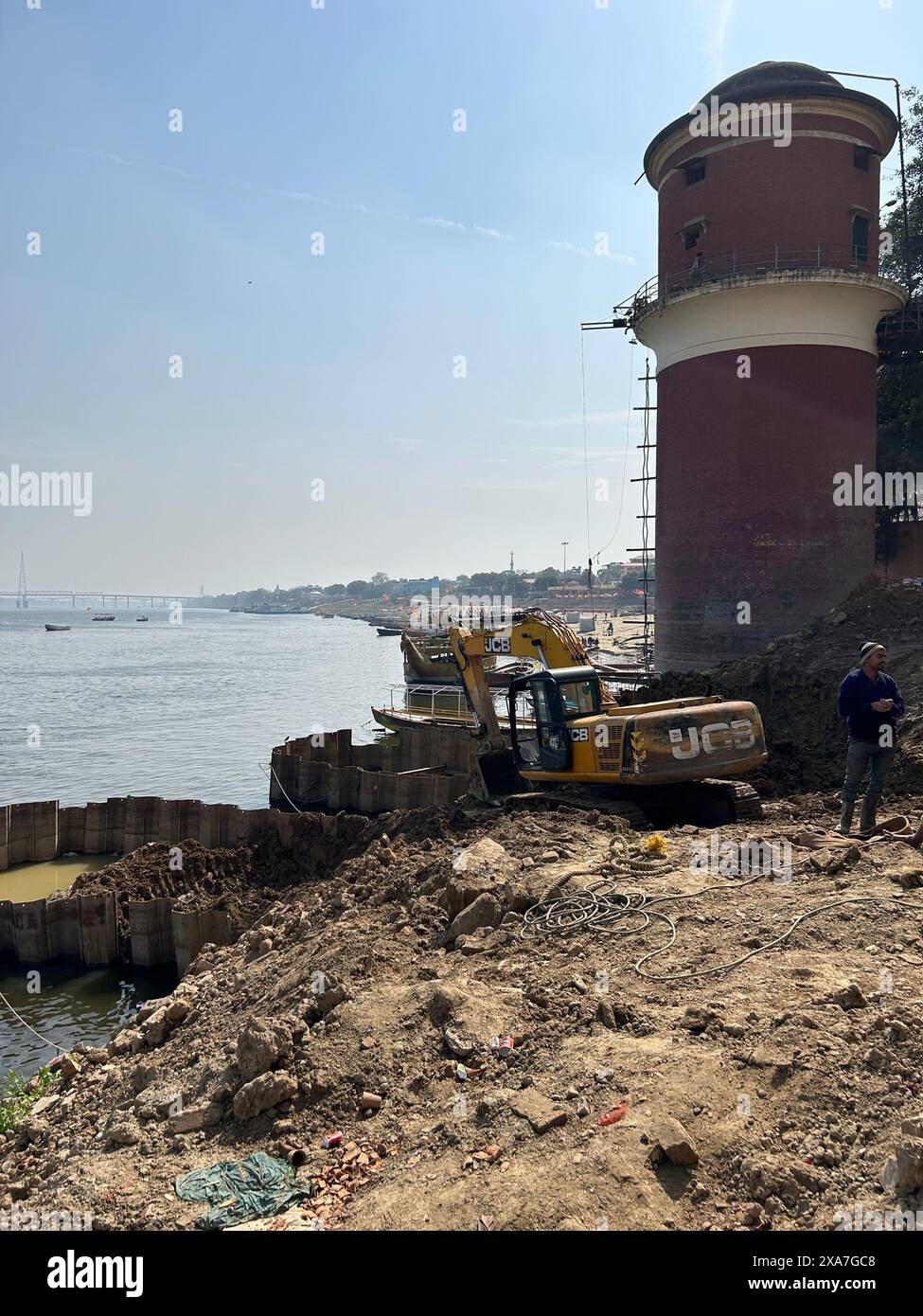 Une figure près de la rive à côté de la tour avec deux grues Banque D'Images