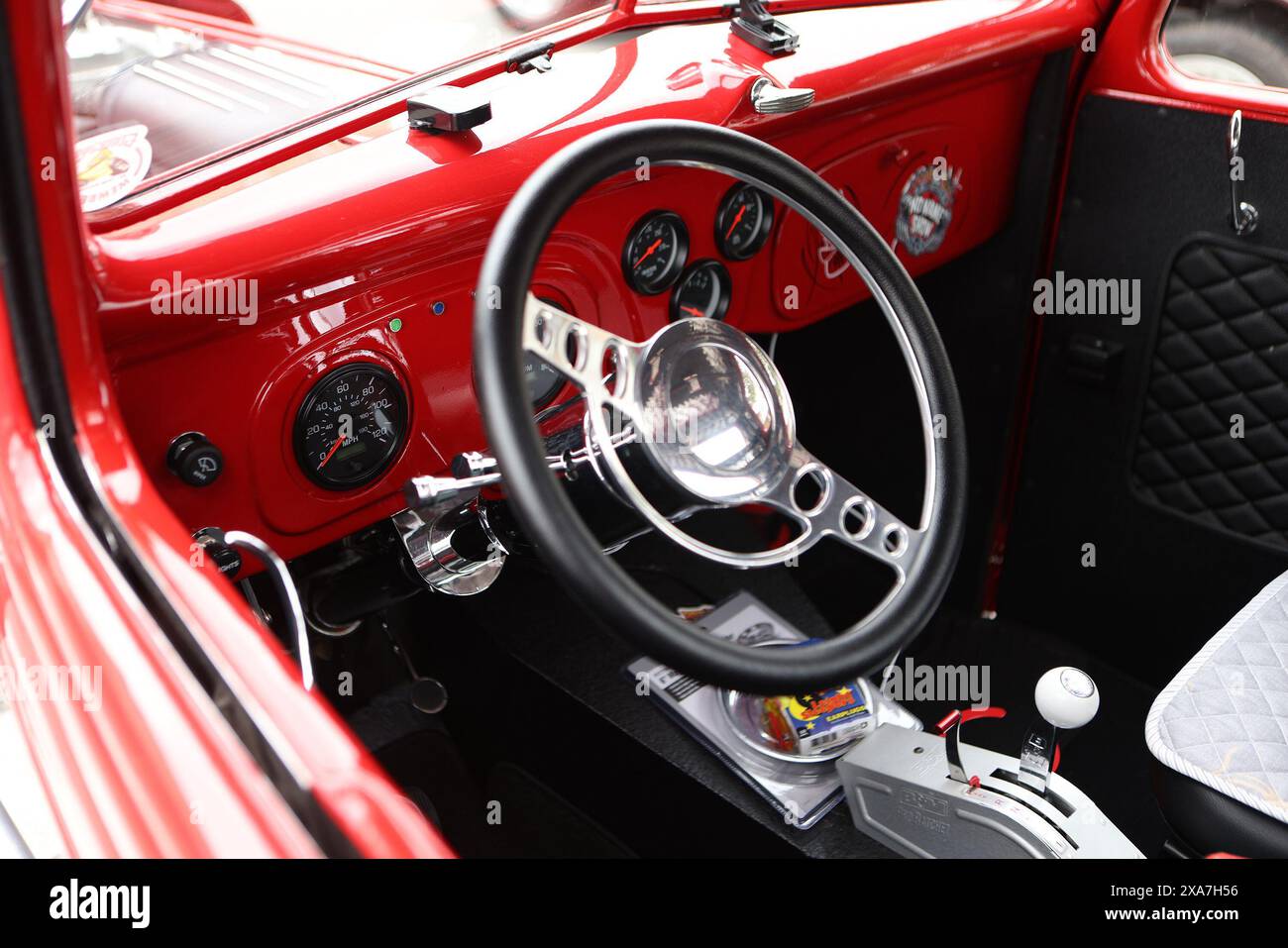 Un tableau de bord de voiture rouge vintage avec sellerie et boutons en cuir Banque D'Images