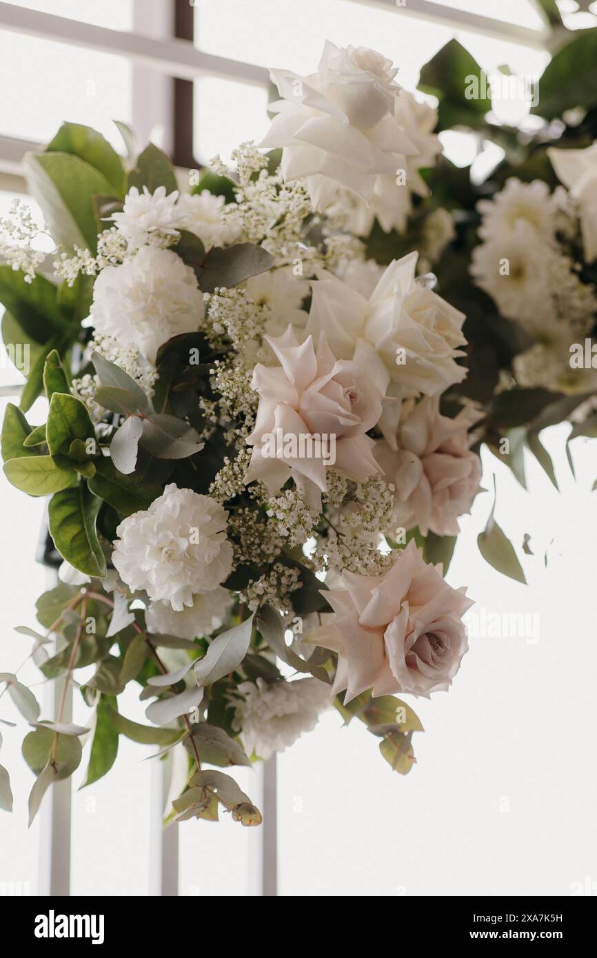 Bouquet floral par une fenêtre avec rideaux Banque D'Images