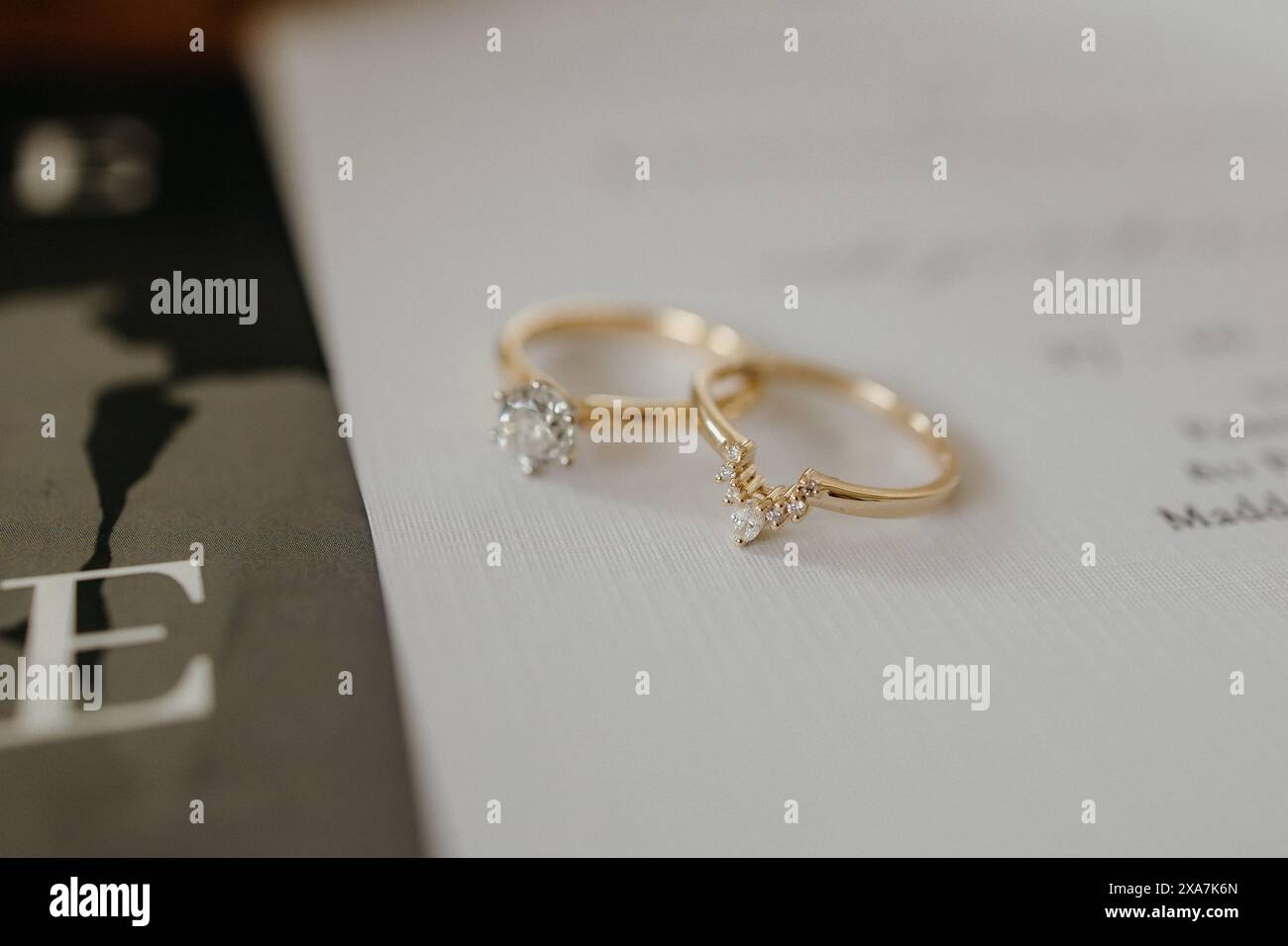 Deux bagues de mariage en diamant placées sur un livre dans un cadre romantique Banque D'Images