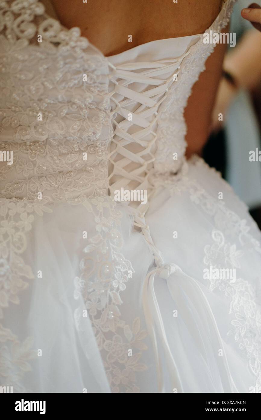 Une mariée ajustant sa robe de mariée blanche Banque D'Images