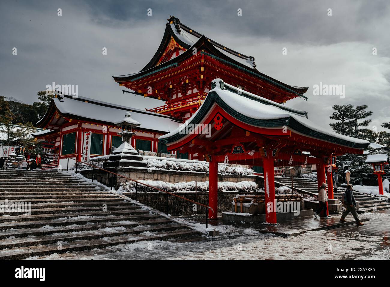 Les adorateurs japonais et les touristes à l'ancienne porte japonaise et les temples couverts de neige rare d'hiver au sanctuaire Fushimi Inari à Kyoto Japon. Banque D'Images