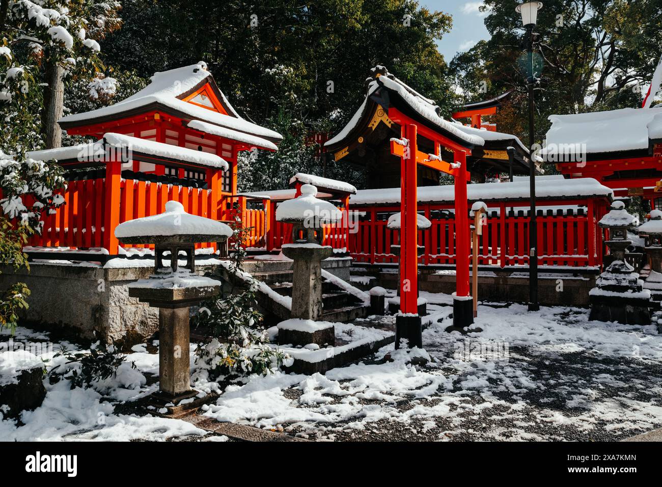 Une ancienne passerelle traditionnelle japonaise et des temples recouverts de neige rare en hiver au sanctuaire Fushimi Inari à Kyoto au Japon. Banque D'Images
