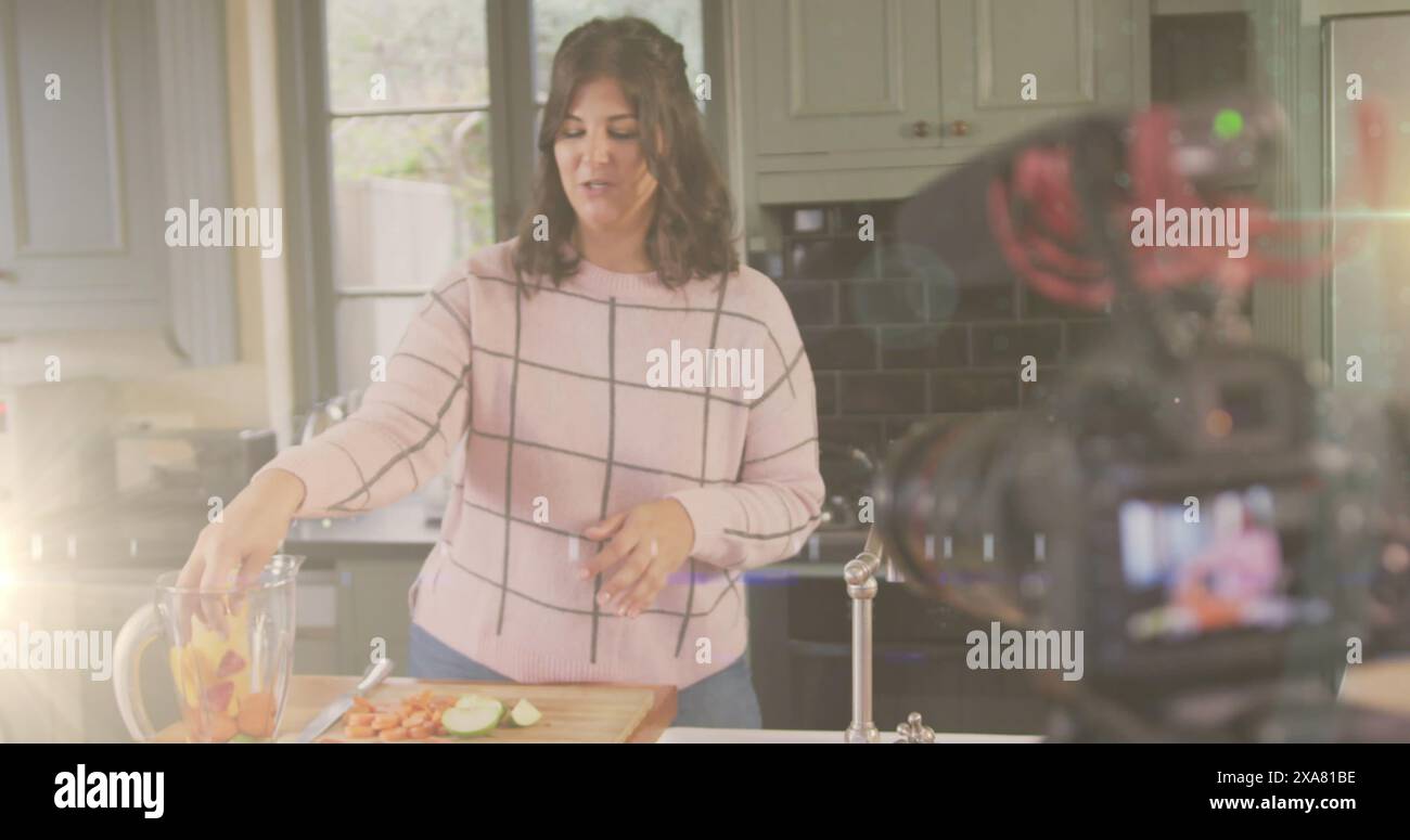 Image d'une lumière brillante au-dessus de la caméra avec un vlogger féminin enregistrant un vlog culinaire à la maison Banque D'Images