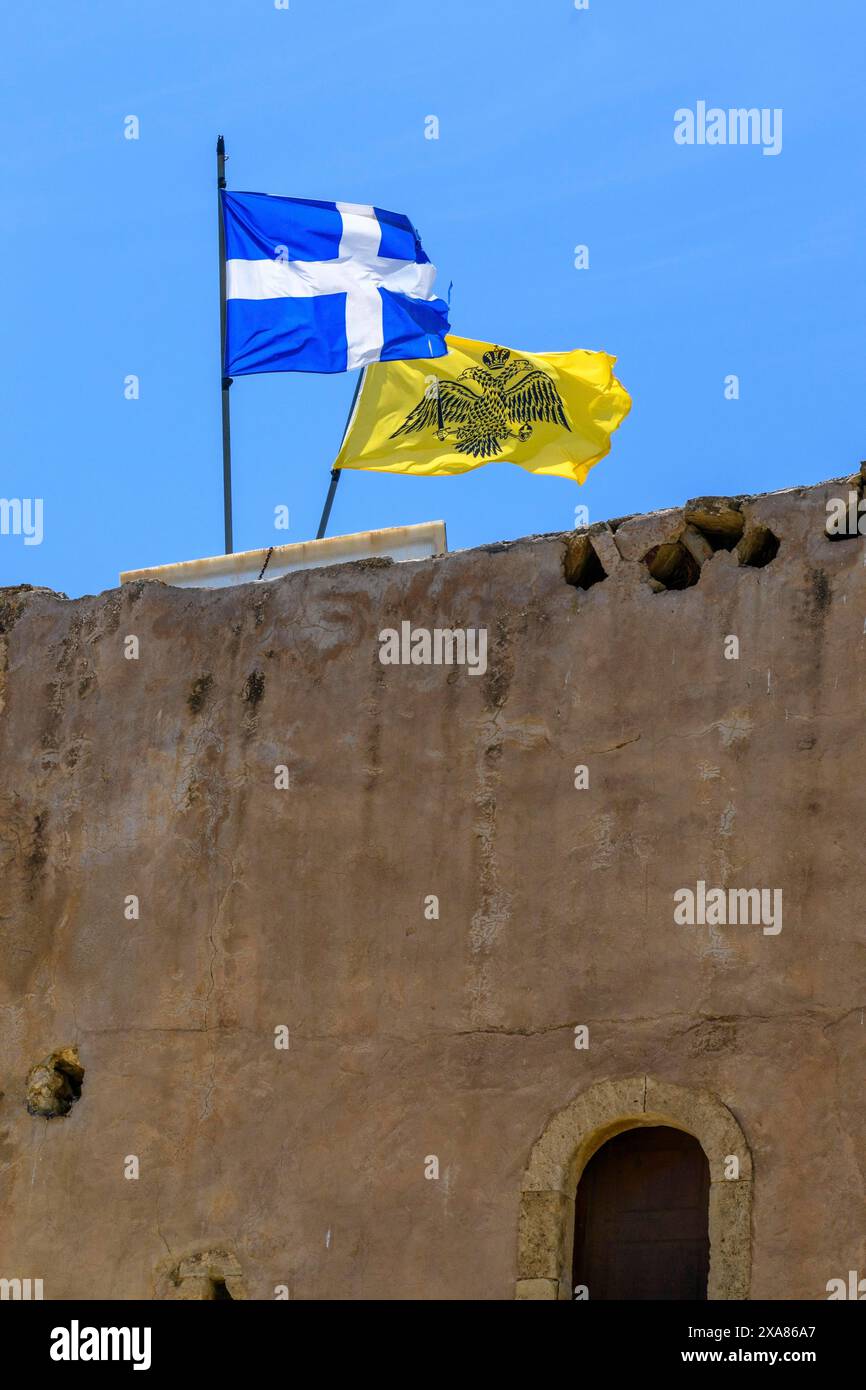 En haut à gauche drapeau de la Grèce derrière lui drapeau avec le symbole de l'Église orthodoxe grecque orthodoxe orientale fond jaune en noir impérial byzantin noir Banque D'Images