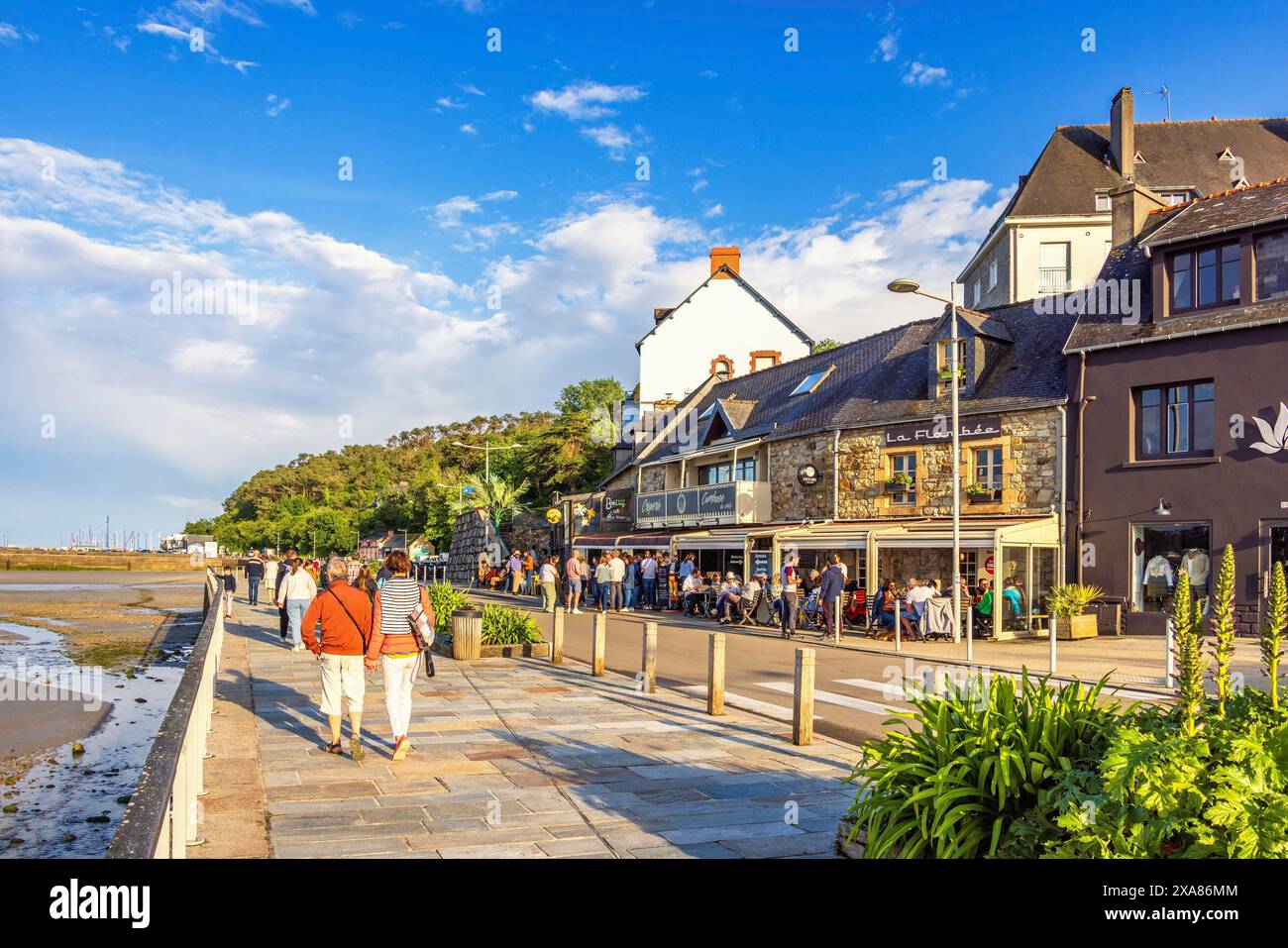 Les gens marchent sur la promenade dans le village de Morgat avec des restaurants dans la lumière du soir, Morgat, Crozon, Bretange, France Banque D'Images