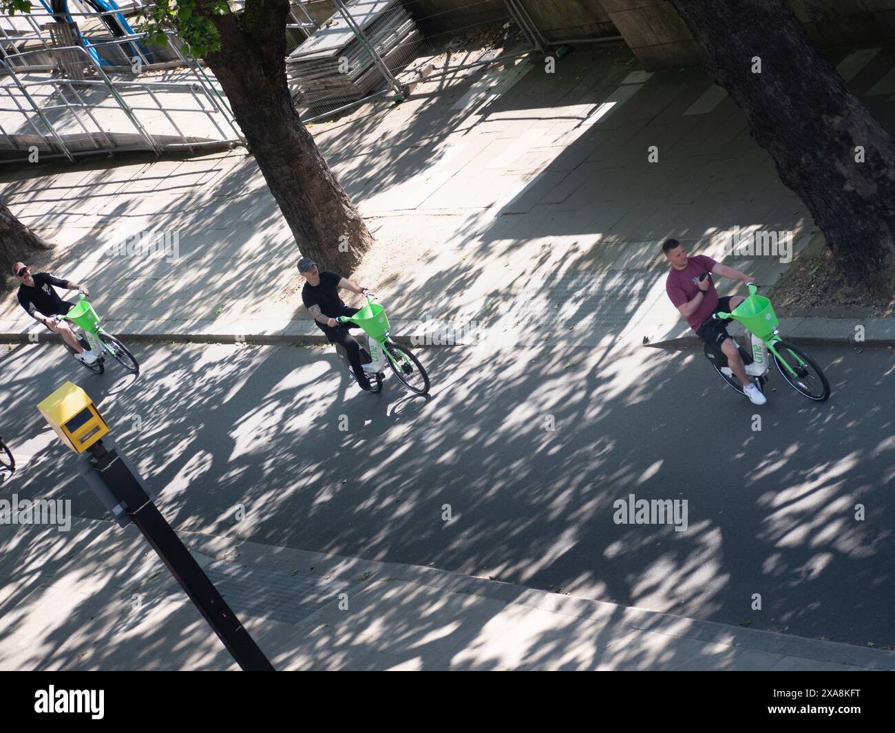 Rangée de cyclistes Lime loués, descendant le remblai dans le centre de Londres, avec caméra de circulation au premier plan Banque D'Images