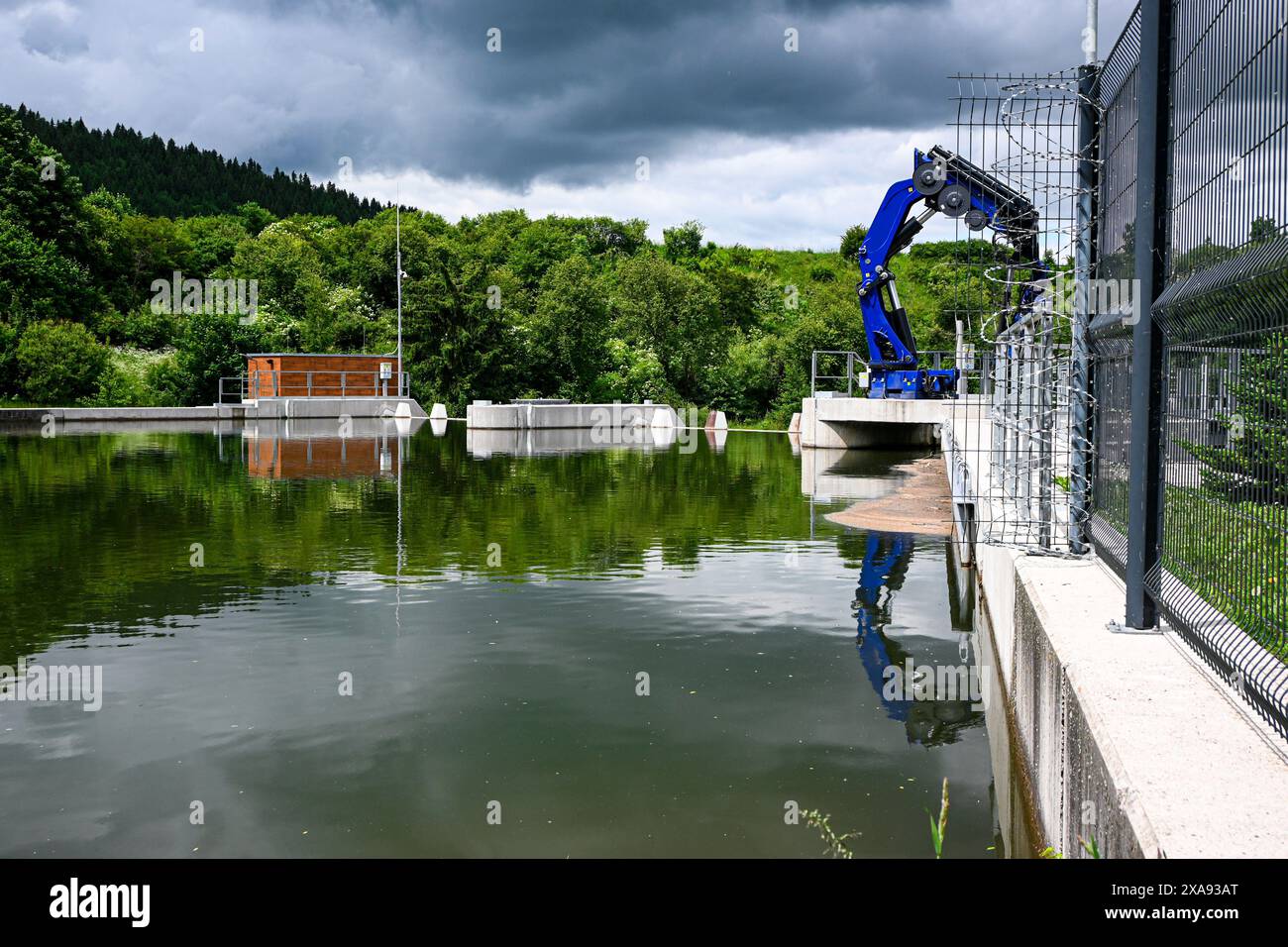 Un petit barrage hydroélectrique fonctionne dans une zone boisée, illustrant la production durable d'énergie. Banque D'Images