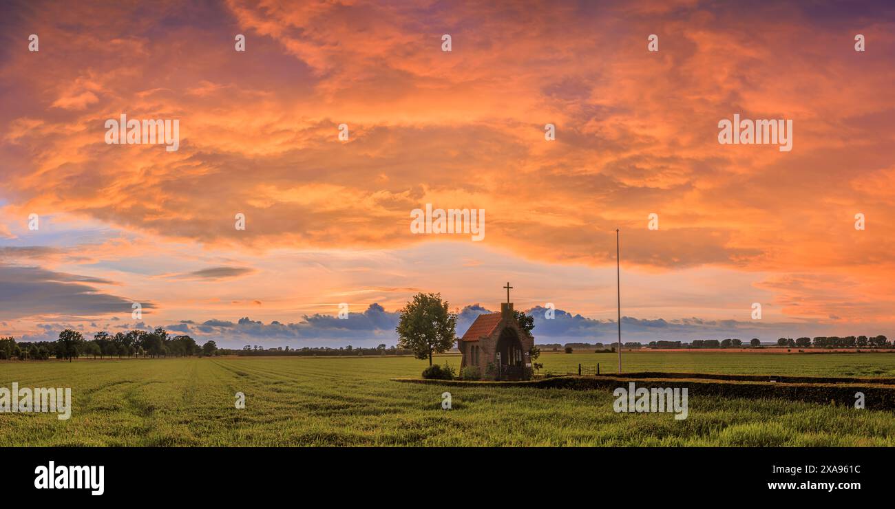 Une large image panoramique 2:1 d'un magnifique coucher de soleil sur le monument de la seconde Guerre mondiale 'notre Dame de la floraison Betuwe' à Bemmel (municipalité de Lingew Banque D'Images