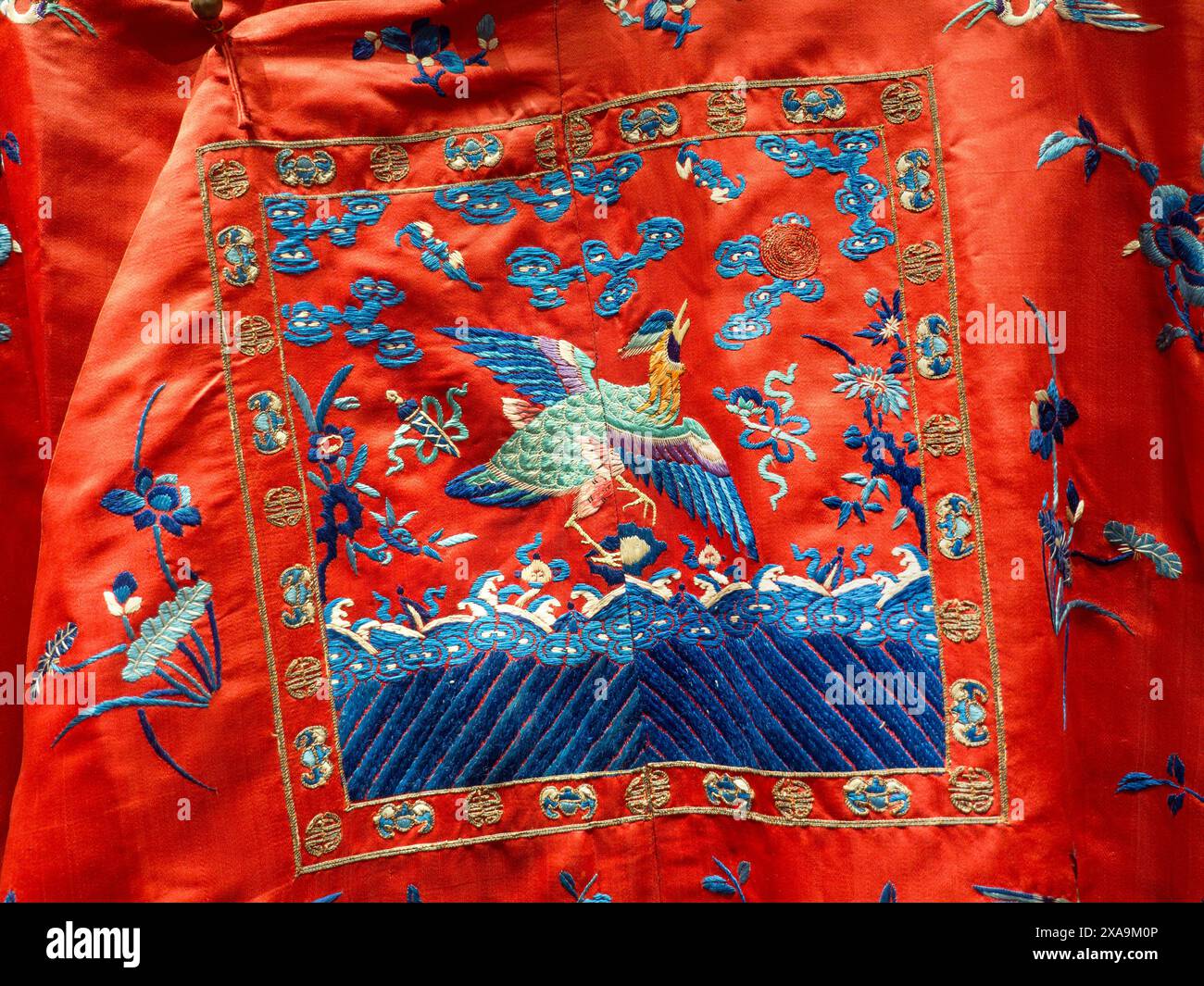 Soie brodée chinoise, Chine historique vintage, robe de cour du 19ème siècle est composée de motifs traditionnels de vagues et de fleurs. Différents oiseaux sont également brodés parmi les motifs. La figure centrale du faisan inscrit indique qu'il s'agit d'un vêtement pour mandarin civil. Lorient ; Compagnie des Indes orientales Bretagne France Banque D'Images