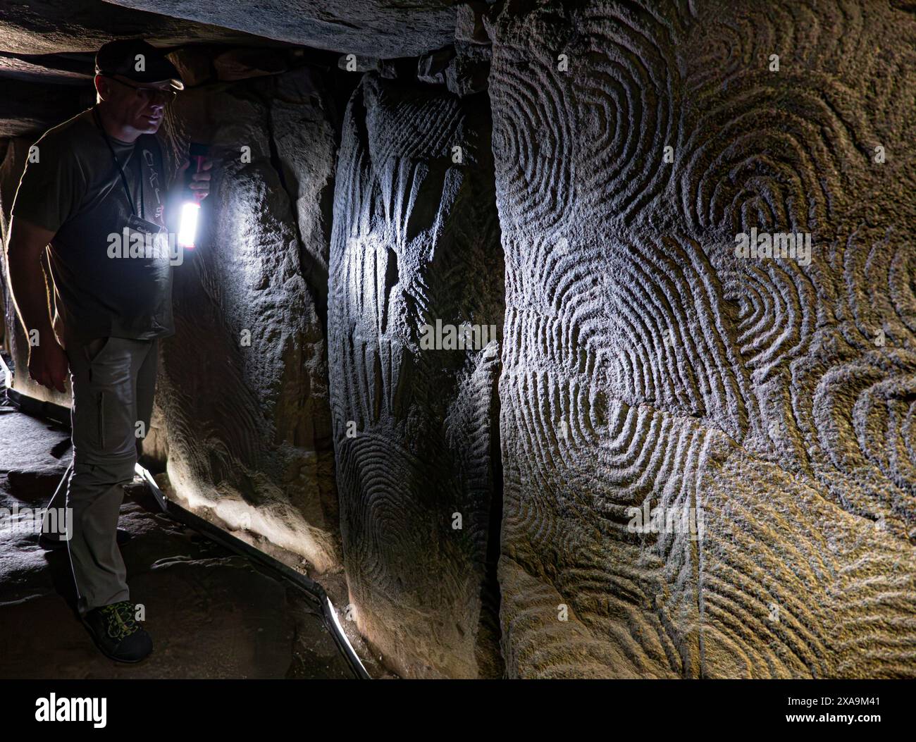 Visite guidée aux flambeaux GAVRINIS GUIDE de sculptures en pierre de l'intérieur de la texture, la France Bretagne cairn préhistorique, dolmen, tombe en pierre sèche, avec le célèbre et symbolique de l'âge de pierre mystérieux sculptures. Un des exemples les plus remarquables de la première apparition de l'architecture dans le monde occidental. Cairn de Gavrinis Cale de Penn-Lannic Sagemor larmor baden, Bretagne France (Megalithes du Morbihan) Banque D'Images