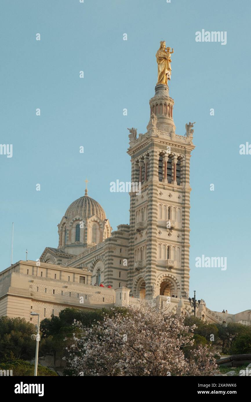 Un grand bâtiment avec une statue dorée sur le dessus et une structure de dôme derrière elle Banque D'Images