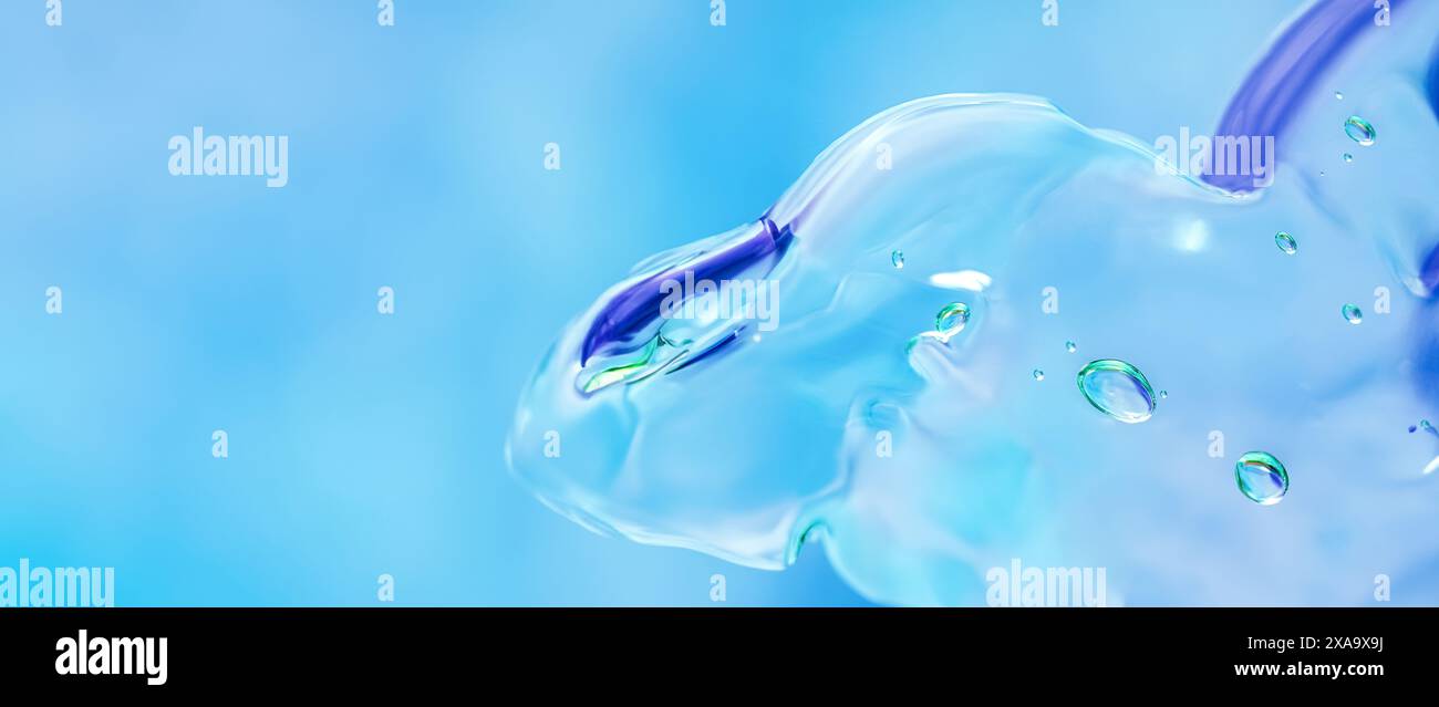 Macro shot de gel cosmétique transparent avec des bulles sur un fond bleu doux. Les bords flous et la mise au point sélective créent un effet texturé. Banque D'Images