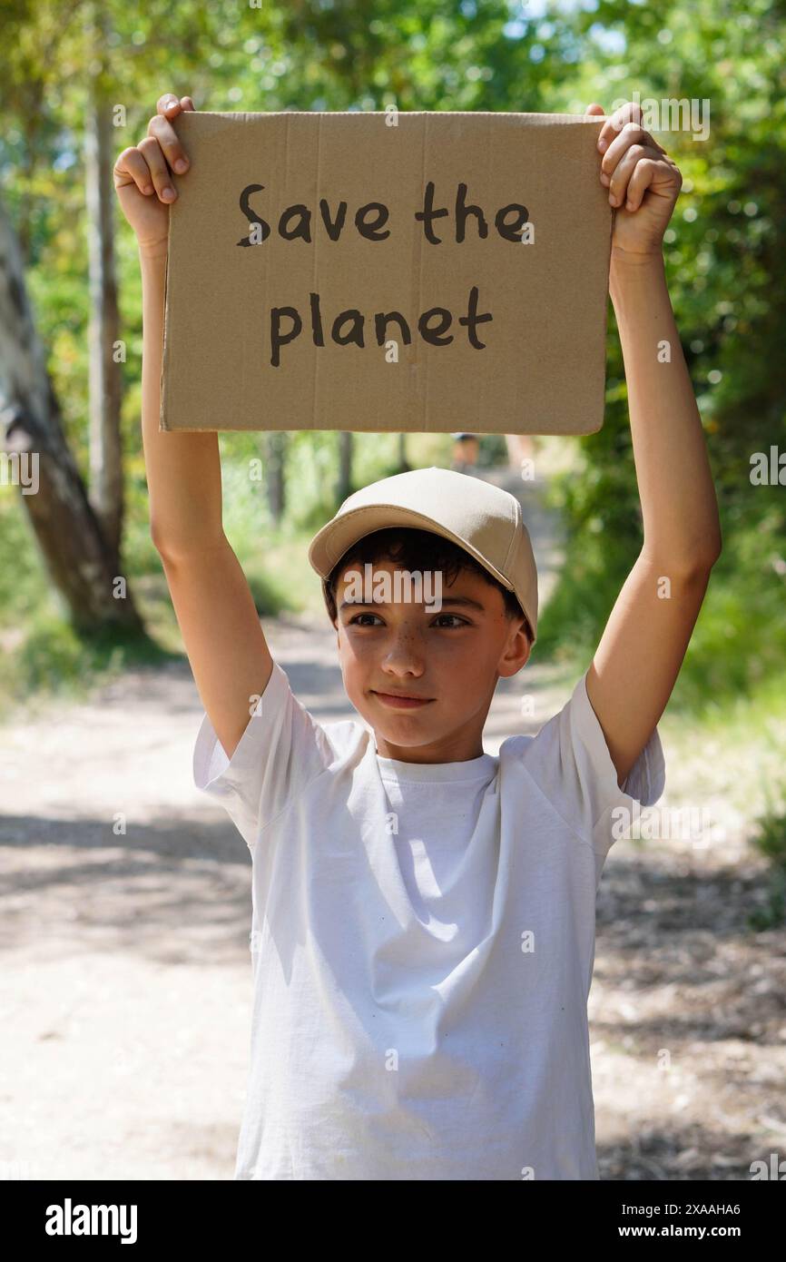 Enfant preteen dans la nature avec poster SAUVER LA PLANÈTE Banque D'Images