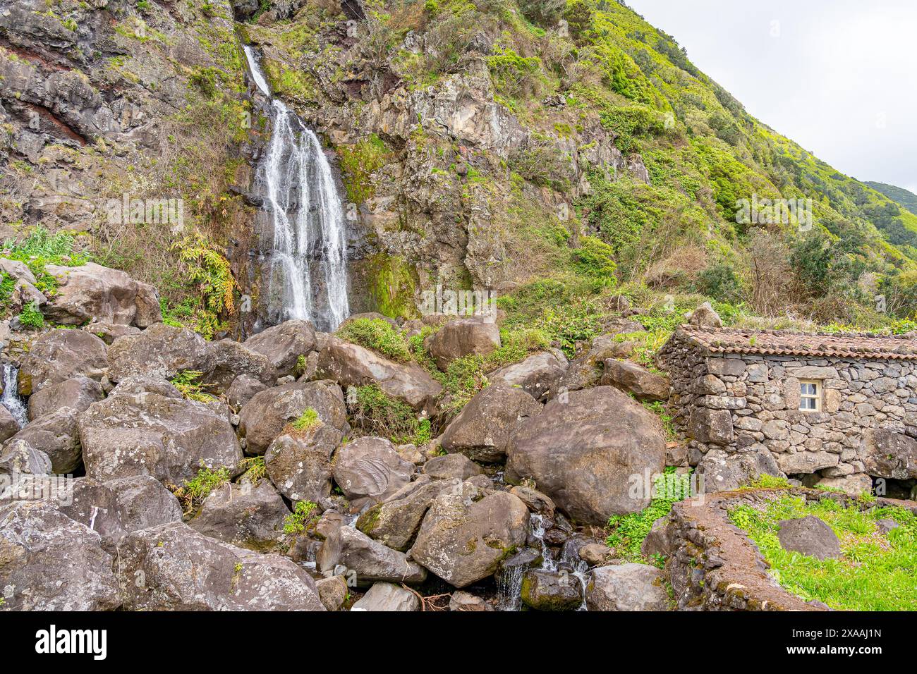 Cascade et petite maison rustique à côté de la cascade Fajã dos Bodes-São Jorge Island-Açores-Portugal. Banque D'Images