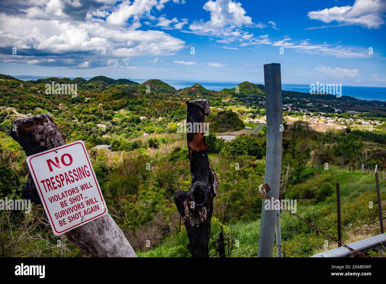 Pas de signe d'intrusion, disant "les contrevenants seront abattus... Survivors Will Be Again » avec pour toile de fond Rincón, la côte tropicale luxuriante de Porto Rico Banque D'Images