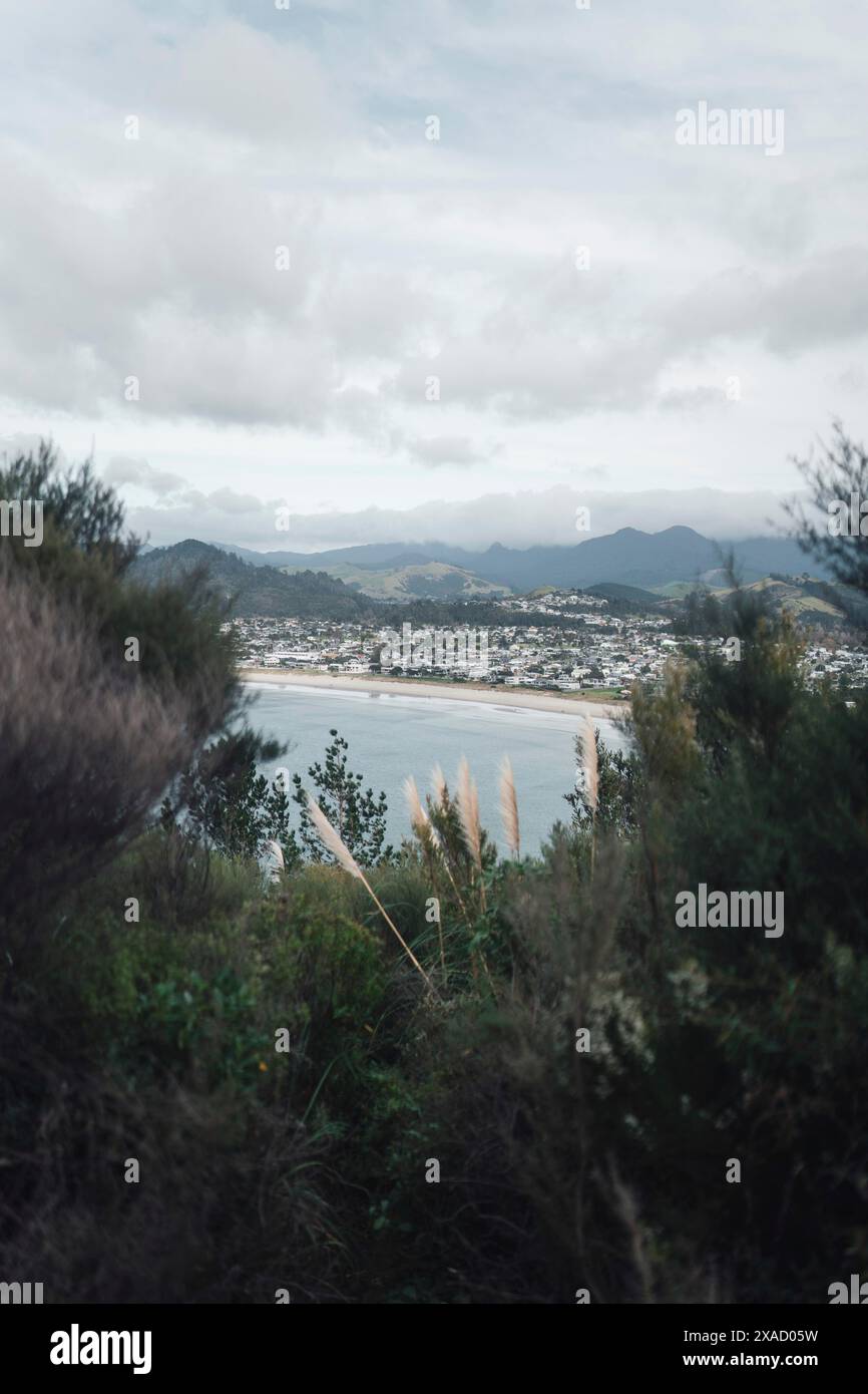 Un paysage côtier avec des montagnes, un temps frais et des nuages dans le ciel, Whangamata, Nouvelle-Zélande Banque D'Images