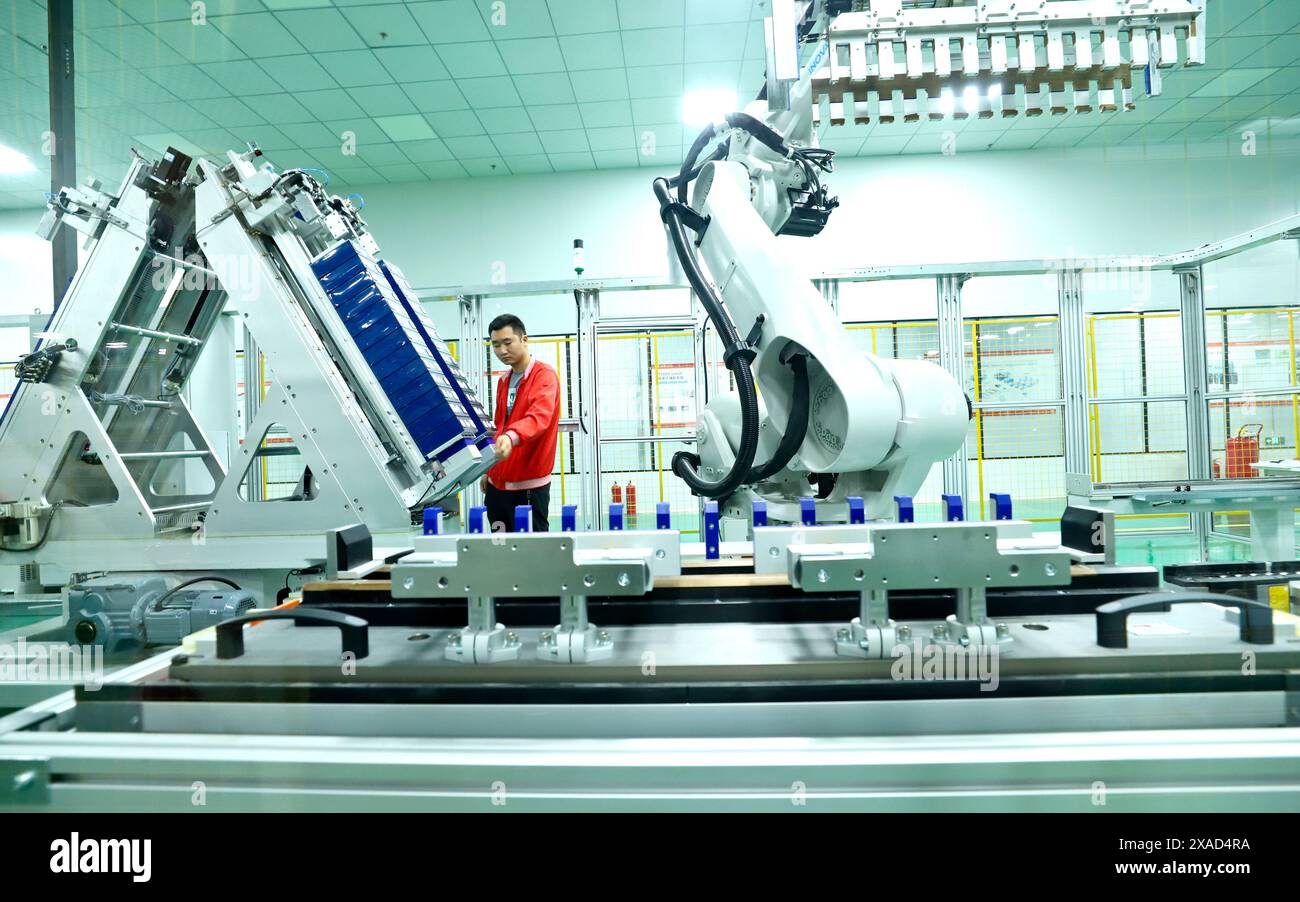 ZHANGYE, CHINE - 5 JUIN 2024 - les travailleurs observent le fonctionnement d'un robot de module de stockage d'énergie à une ligne de production automatisée de stockage d'énergie Equi Banque D'Images