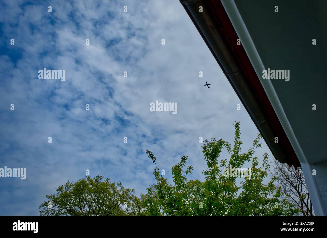 Un regard par une fenêtre, où un avion est volant dans le ciel, image symbolique Banque D'Images