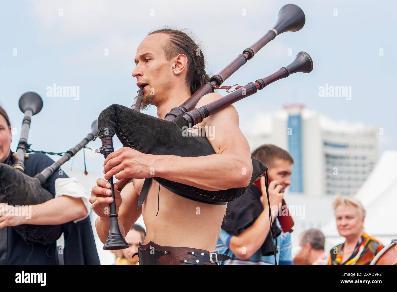 Groupe de musique Irdorath. Musiciens de rue : cornemuse avec un torse nu en armure de cuir jouant Banque D'Images