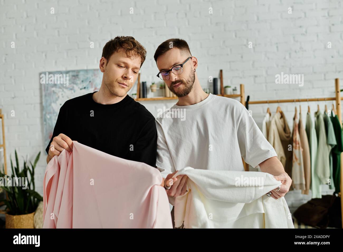 Deux hommes, partenaires dans le design, prennent la pose dans leur atelier de pointe. Banque D'Images