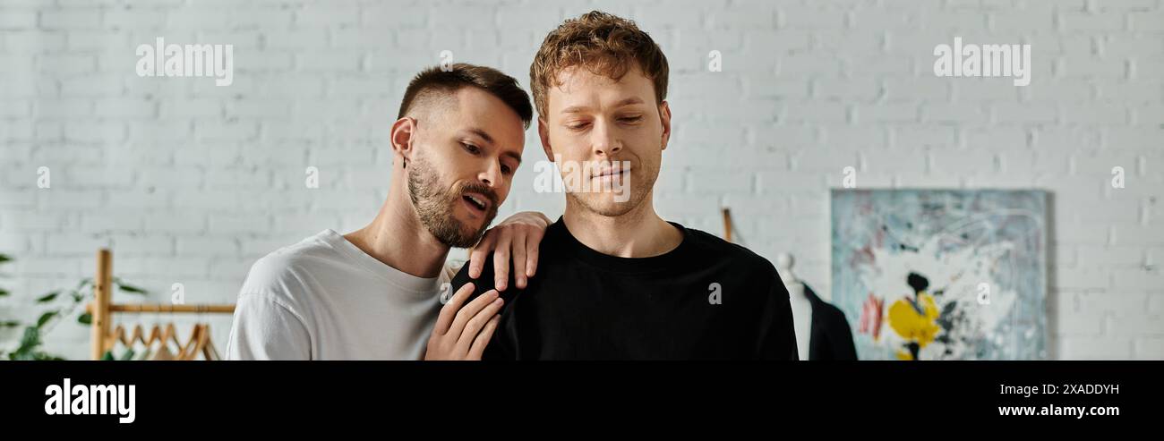 Un couple gay, travaillant ensemble dans un atelier de designer, créant des vêtements tendance. Banque D'Images