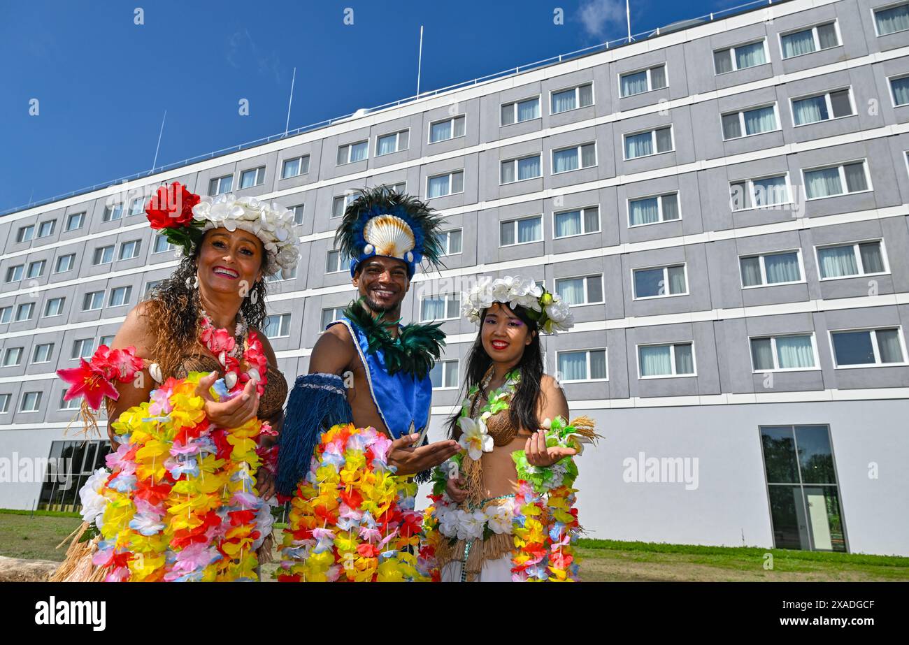 06 juin 2024, Brandenburg, Krausnick : des danseurs de la compagnie de danse 'Yussara' en costumes hawaïens se tiennent devant le nouveau bâtiment à l'ouverture du complexe hôtelier 'Ohana' au Tropical Island Resort. Le Tropical Island Resort a ouvert son nouveau complexe hôtelier sur le côté est du Tropical Hall. Photo : Patrick Pleul/dpa Banque D'Images