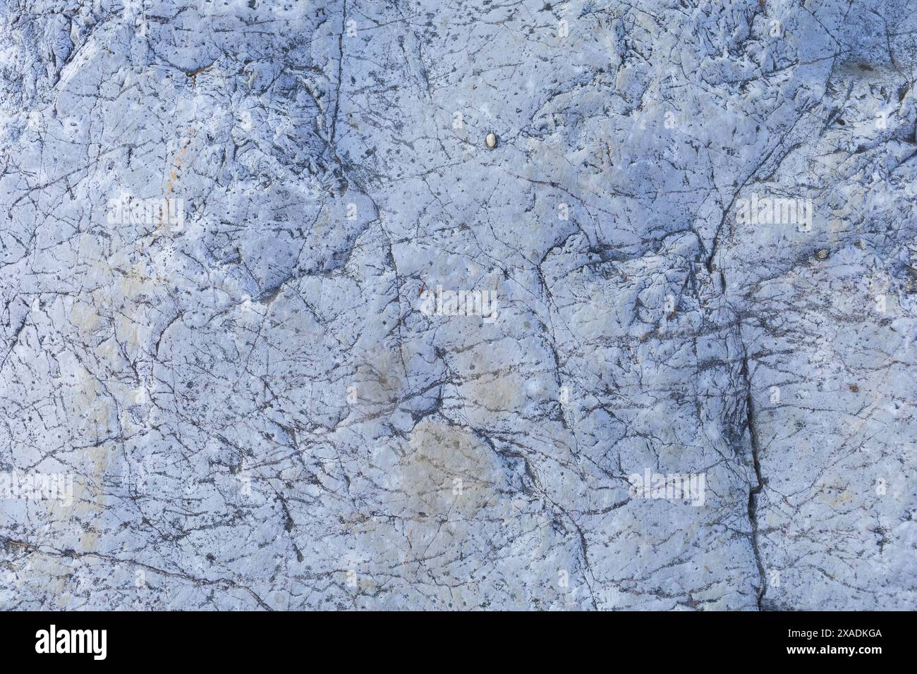 photographie à plat d'une pierre de granit gris bleu clair avec une surface texturée fissurée Banque D'Images