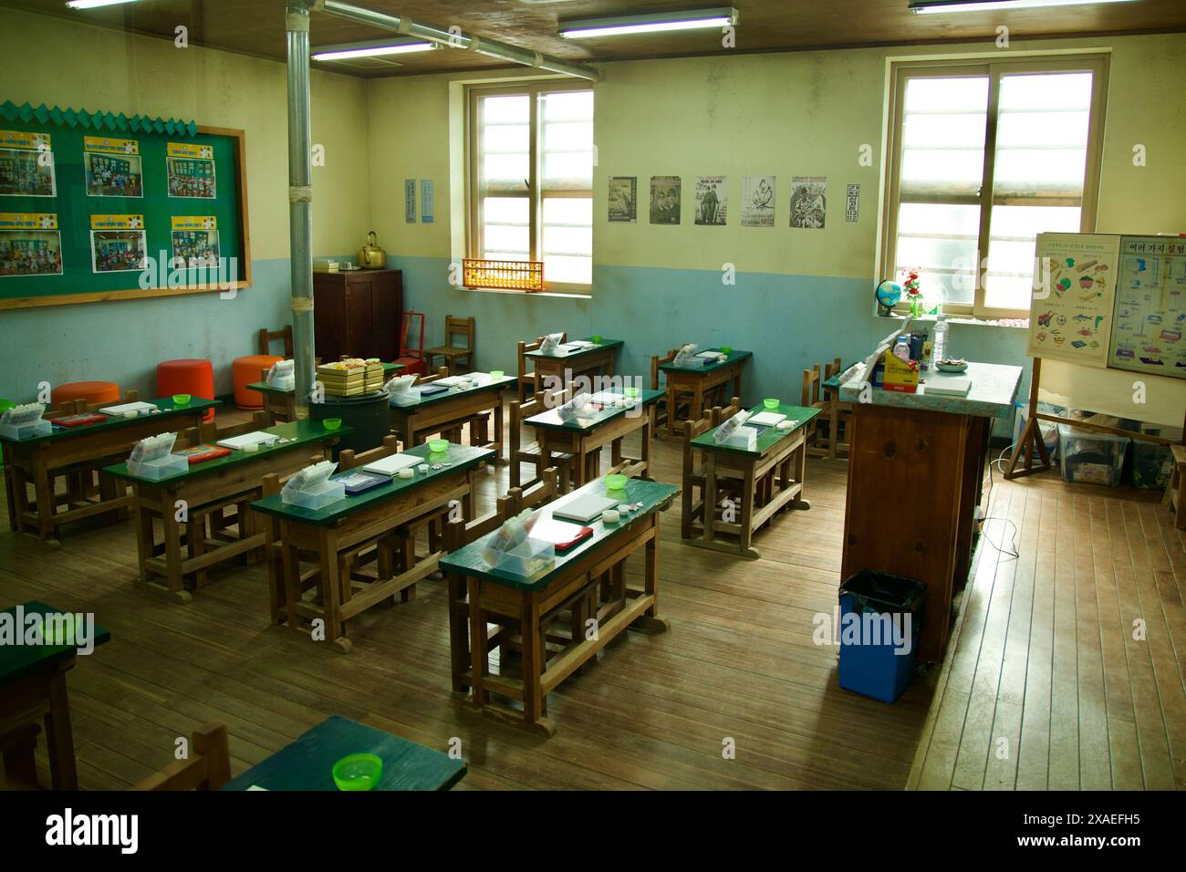 Ulsan, Corée du Sud - 17 mars 2024 : une salle de classe recréée du milieu du XXe siècle au village de la culture baleine de Jangsaengpo, avec des bureaux en bois, texte ancien Banque D'Images