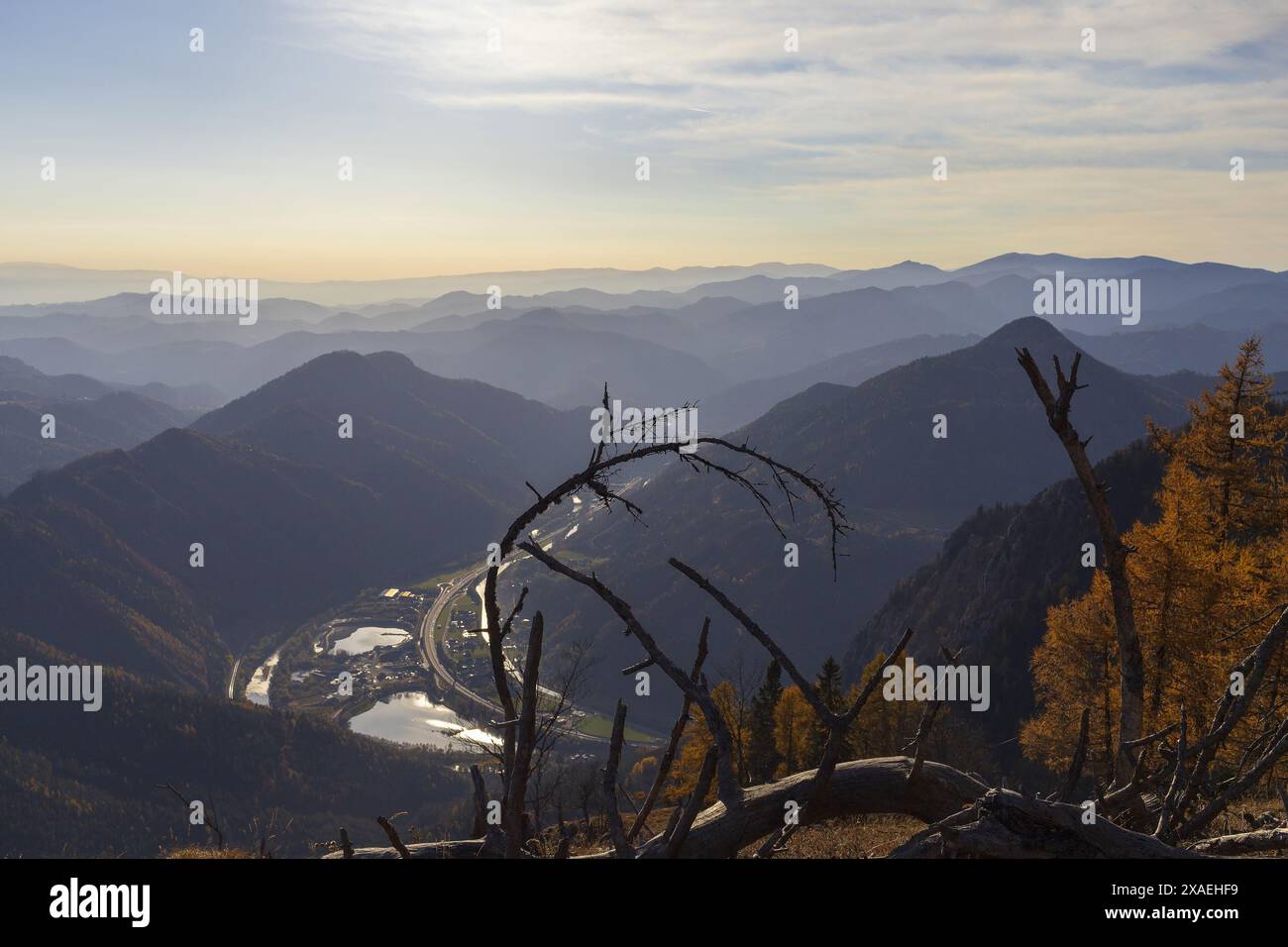 Photographie panoramique des montagnes alpines à une vallée avec rivière et bâtiments sur le coucher du soleil d'automne Banque D'Images